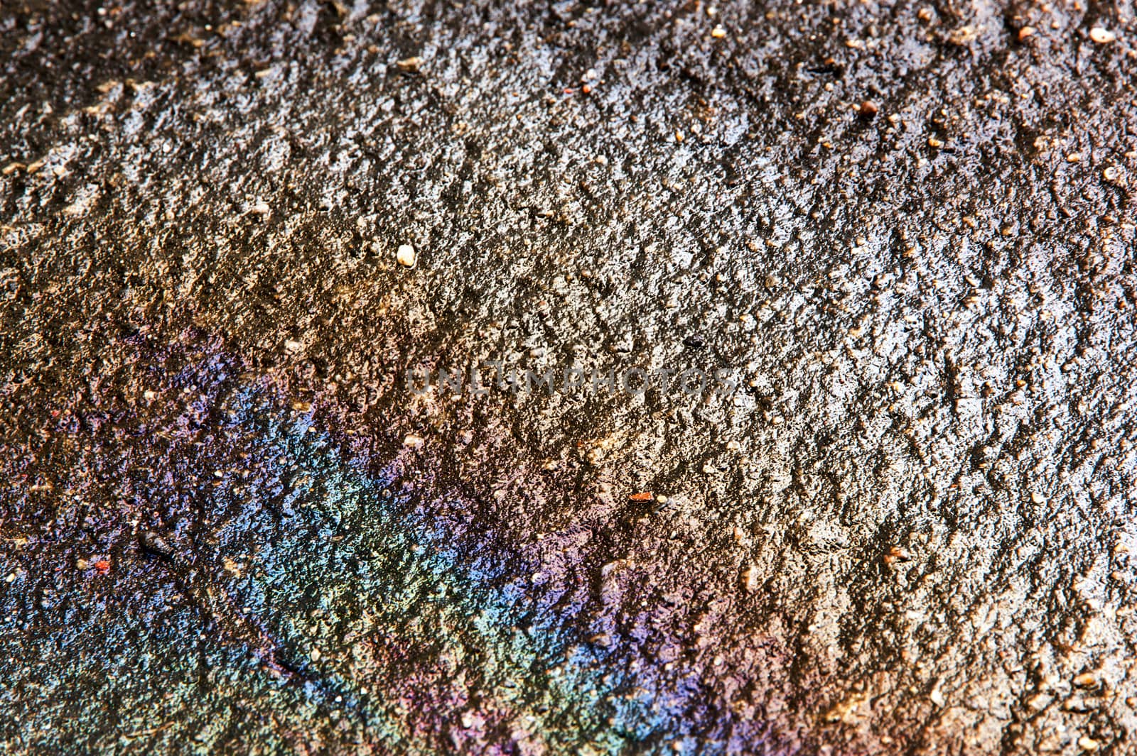 Oil on ground when wet cause rainbow on water on ground concrete