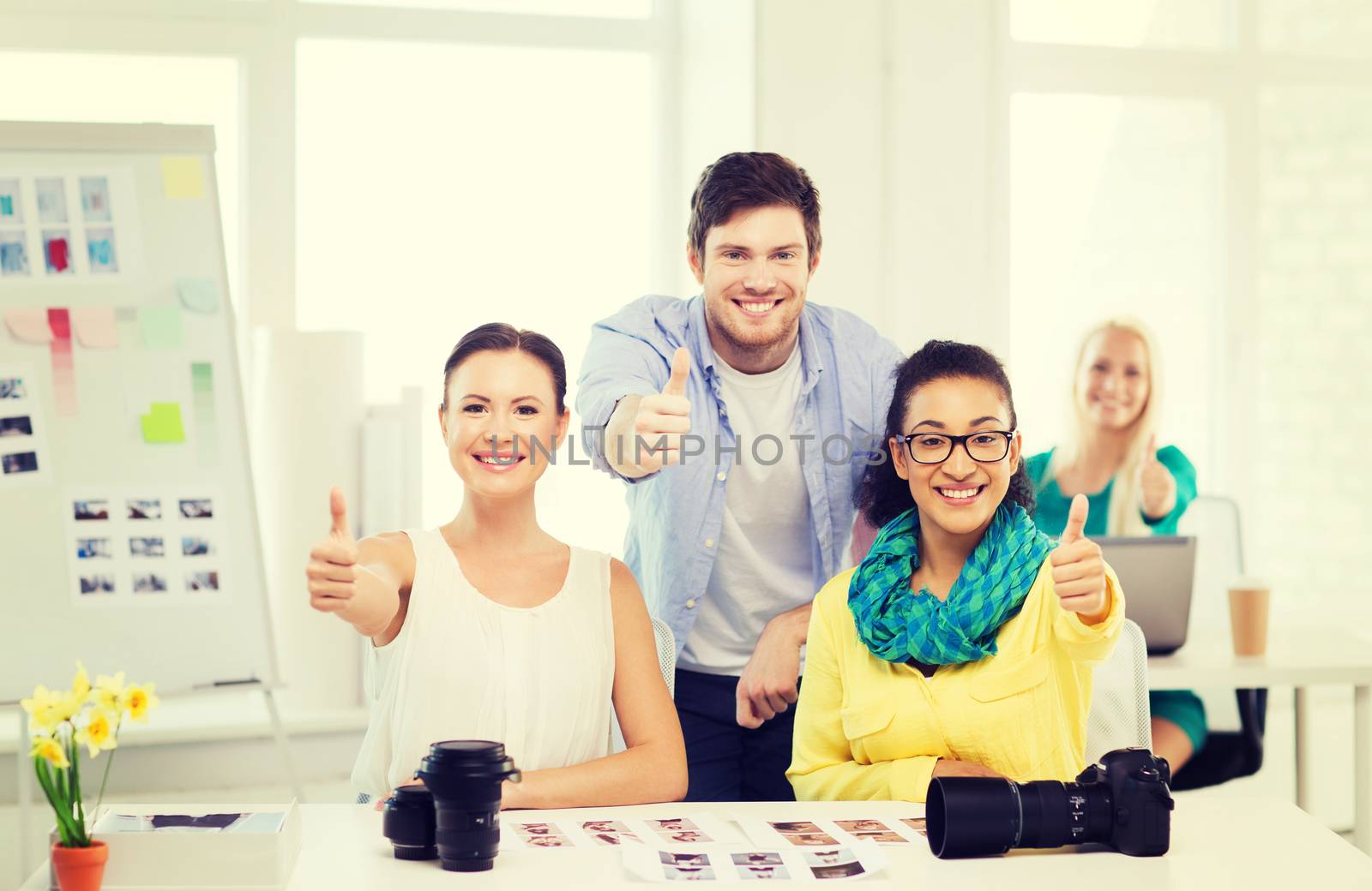 smiling team with photocamera in office by dolgachov