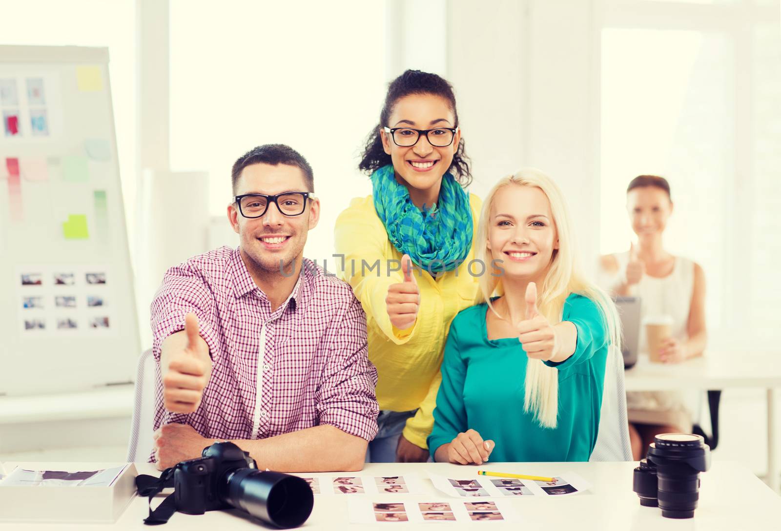 smiling team with printed photos working in office by dolgachov