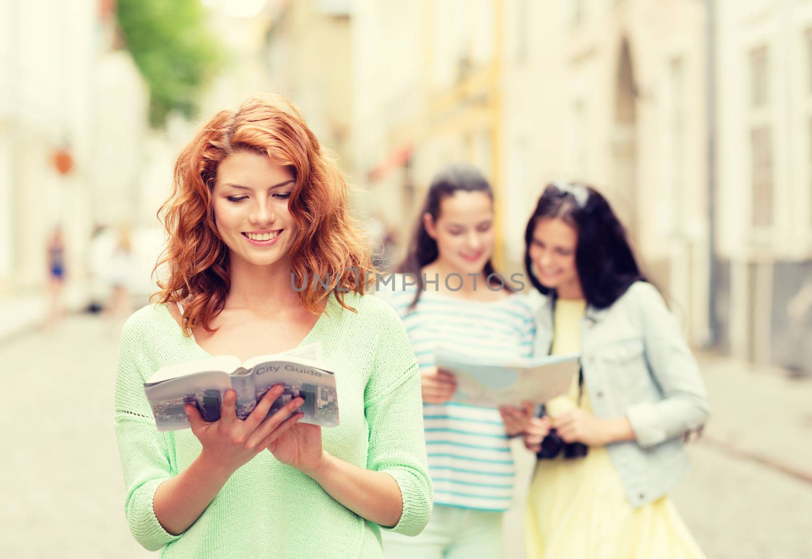 tourism, travel, holidays and friendship concept - smiling teenage girls with city guide, map and camera outdoors