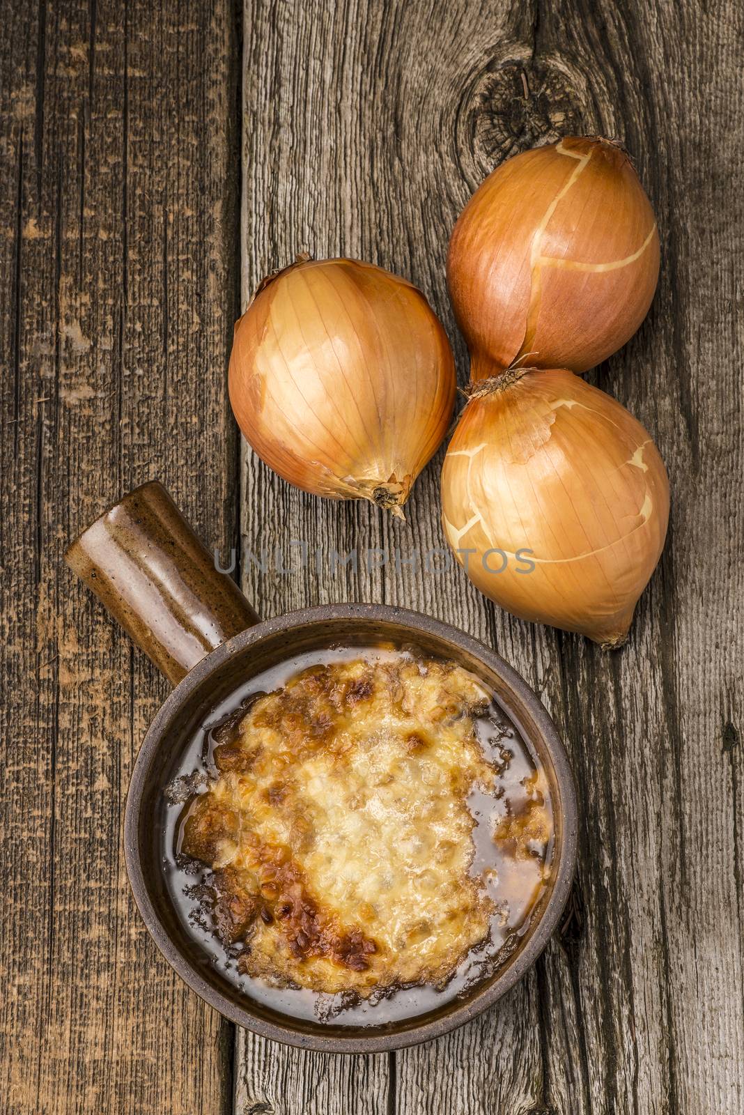A bowl of rustic homemade french onion soup photographed from overhead.