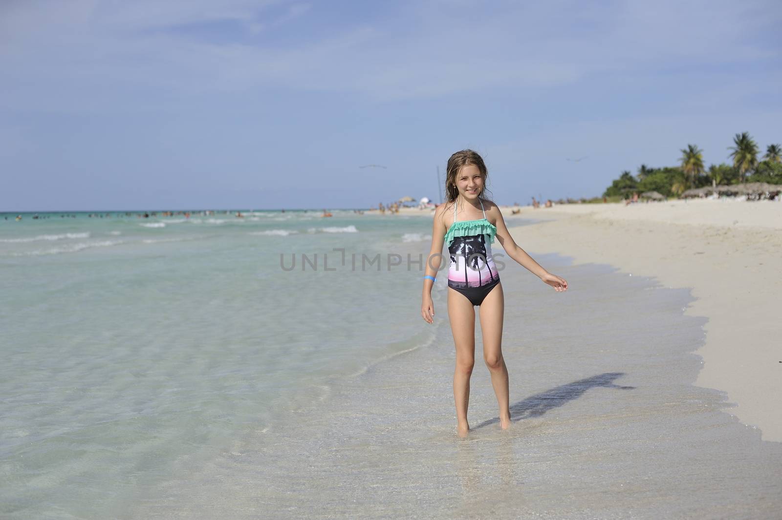 Girl on the Caribbean sunny beach with white sand.