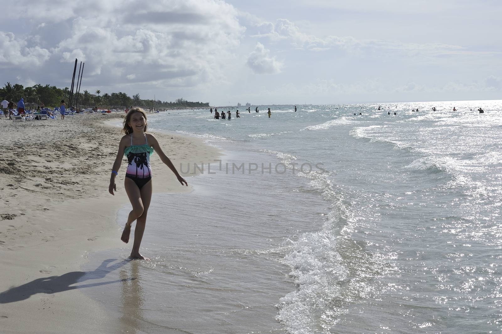 Girl on the Caribbean sunny beach with white sand.