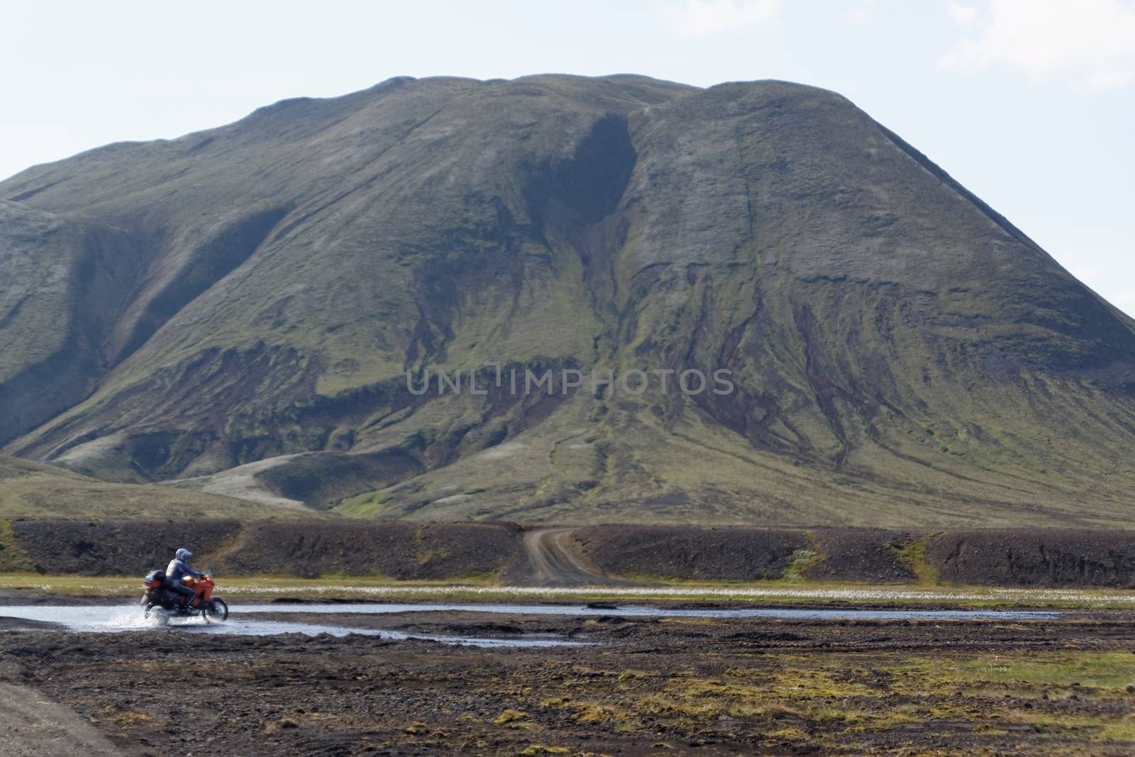 Old volcano,river and biker under old volcano in Iceland