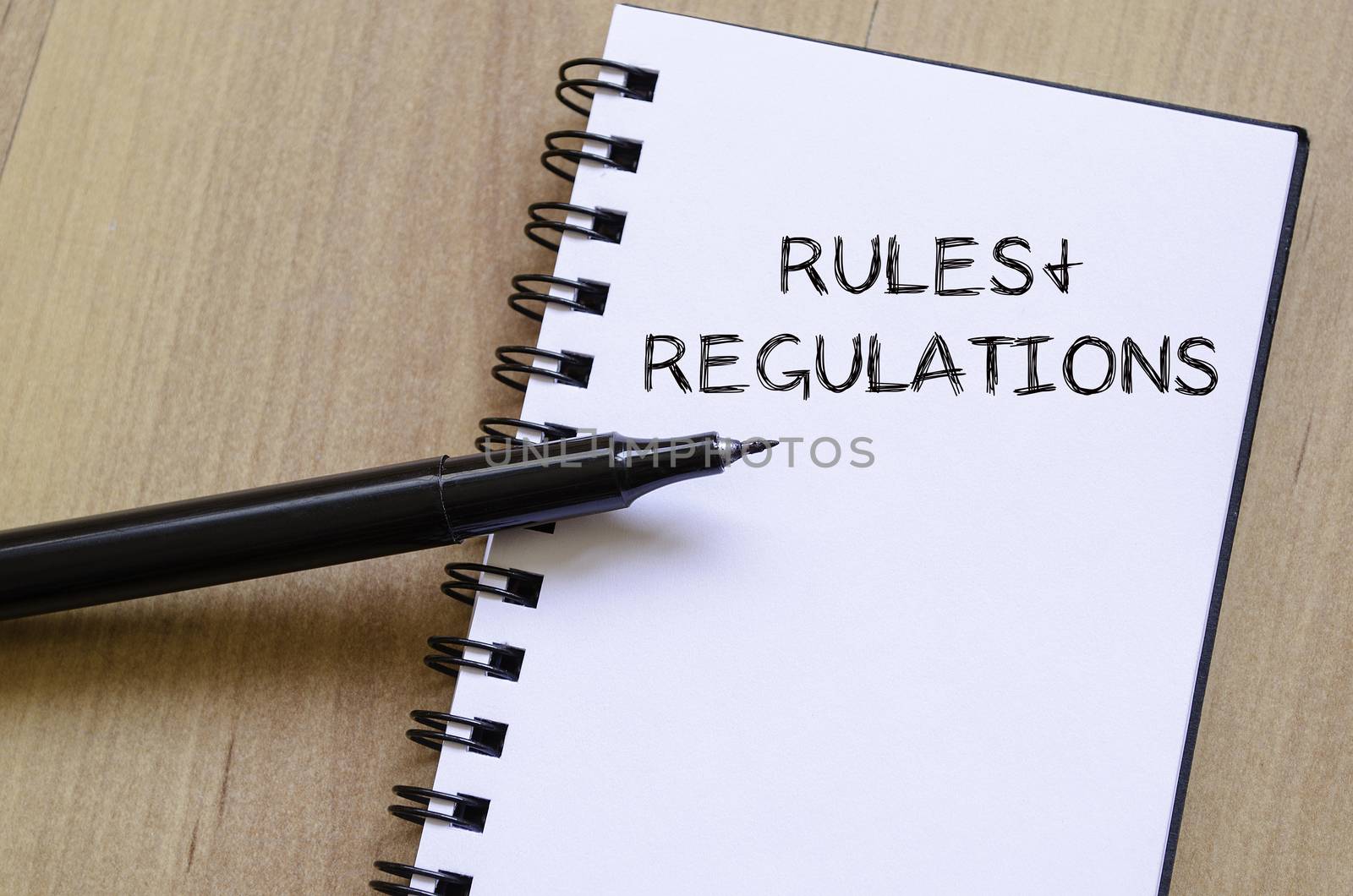 Rules and regulations text concept write on notebook with pen
