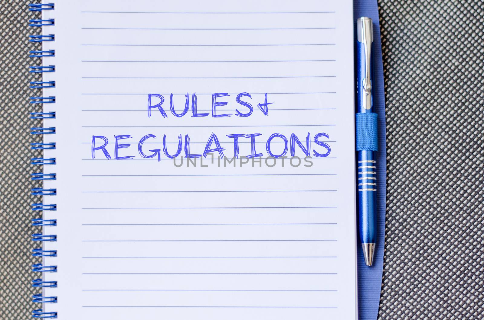 Rules and regulations text concept write on notebook with pen