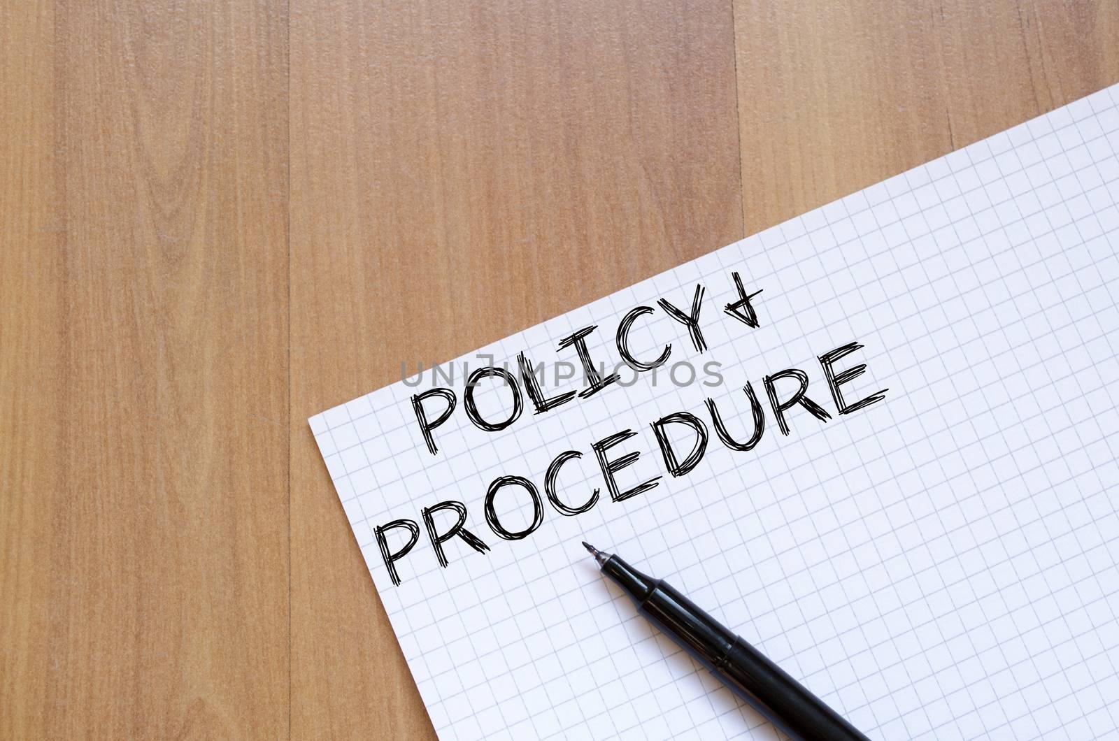 Policy and procedure text concept write on notebook with pen