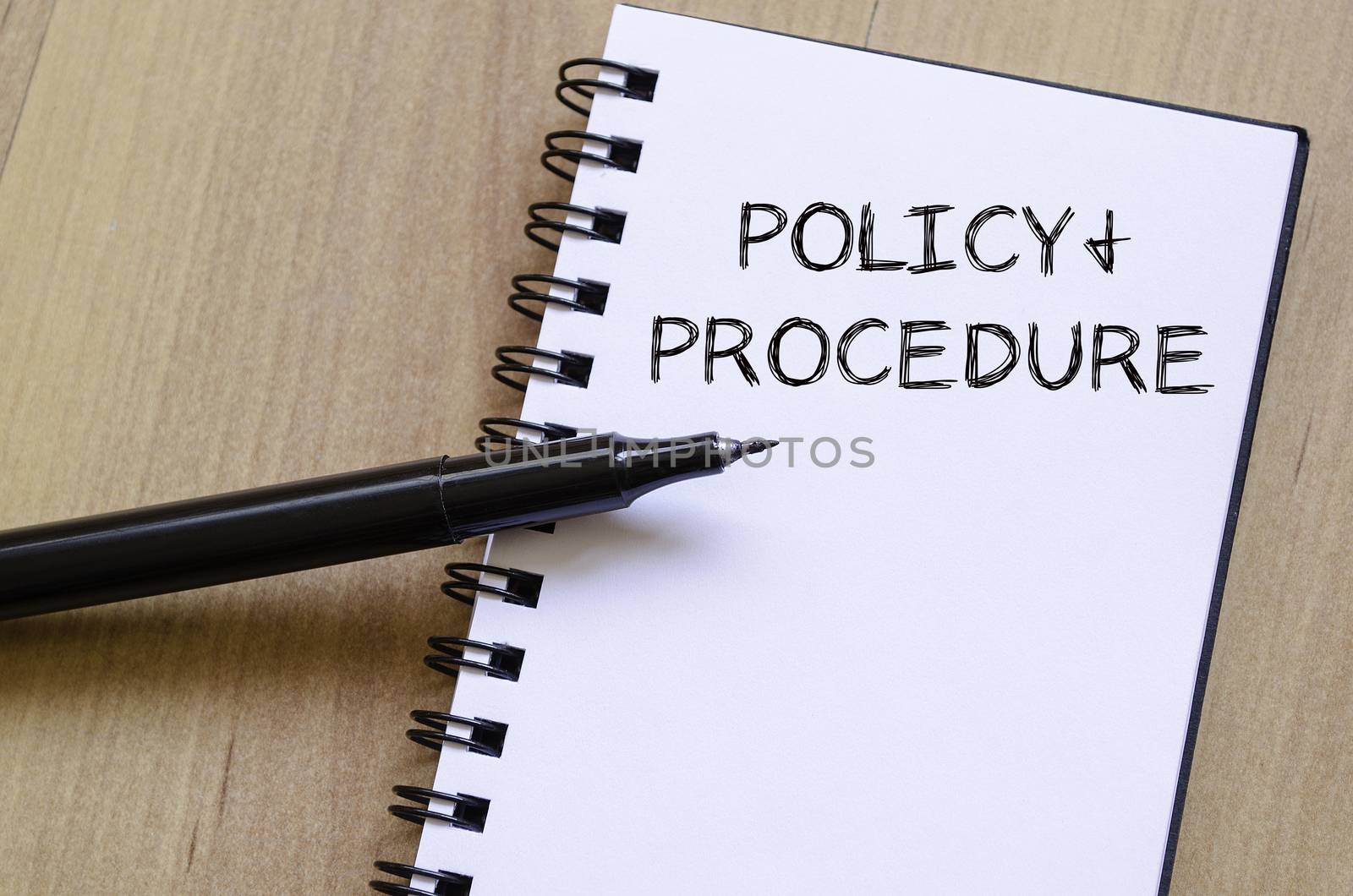 Policy and procedure text concept write on notebook with pen