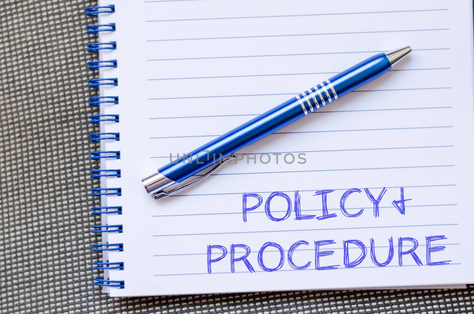 Policy and procedure text concept write on notebook with pen