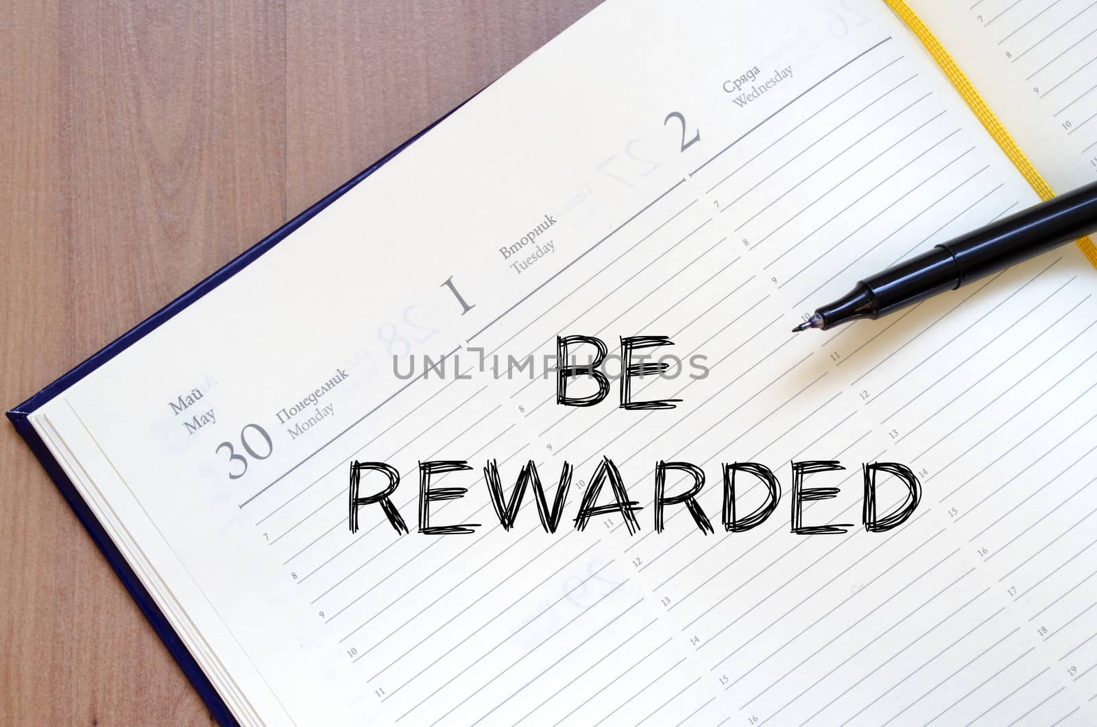 Be rewarded text concept write on notebook with pen