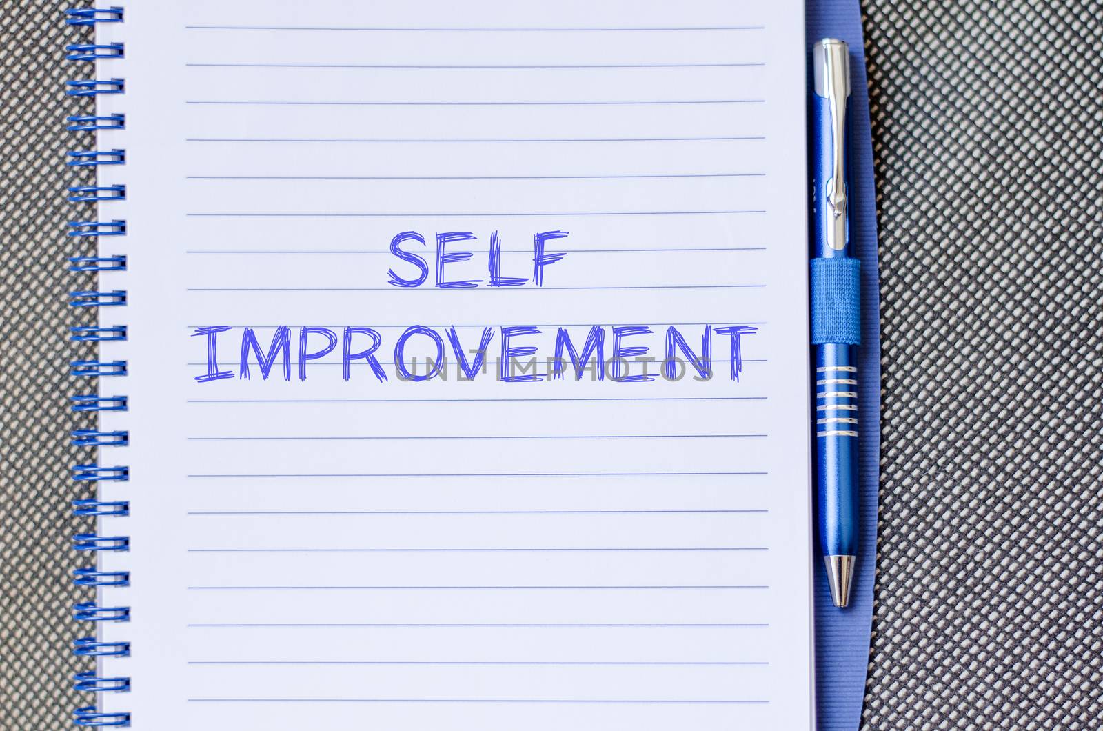 Self improvement text concept write on notebook with pen