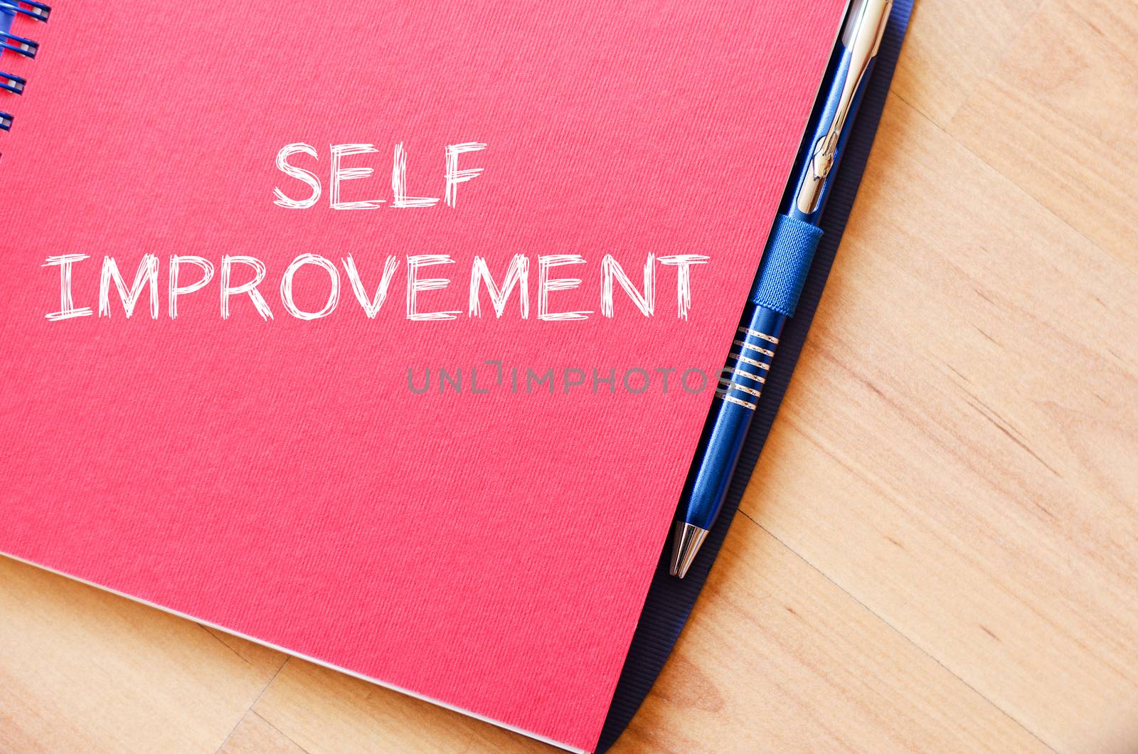 Self improvement text concept write on notebook with pen