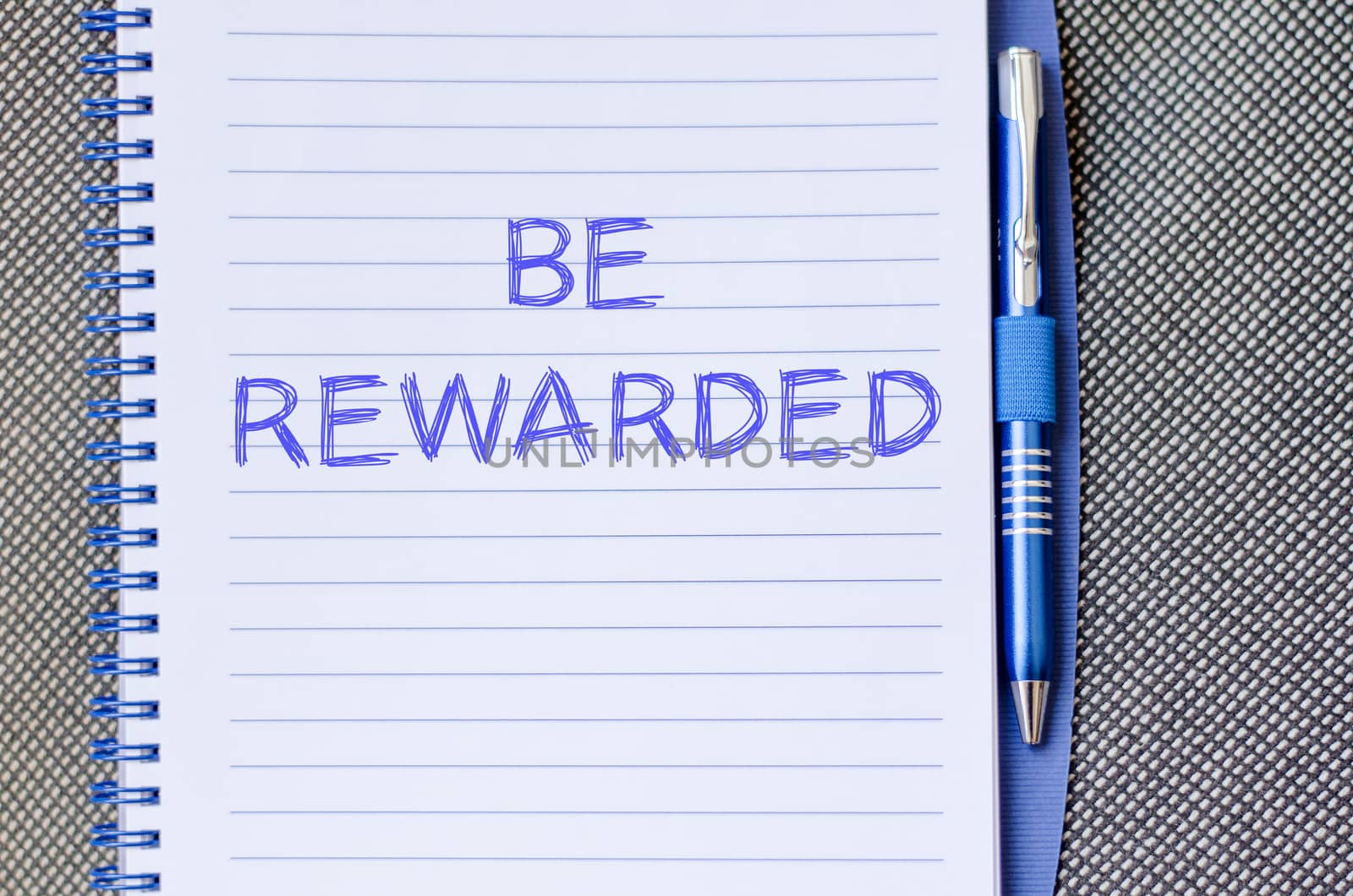 Be rewarded text concept write on notebook with pen