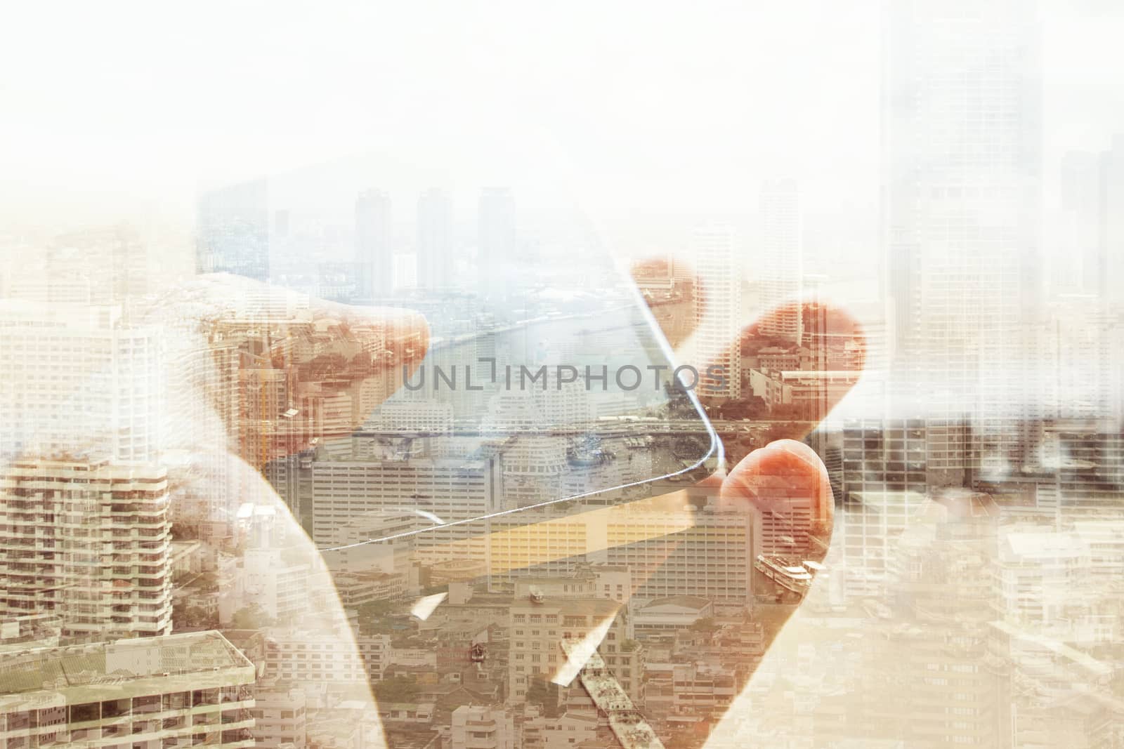 Double exposure of cityscape and smart phone, business technology concept.