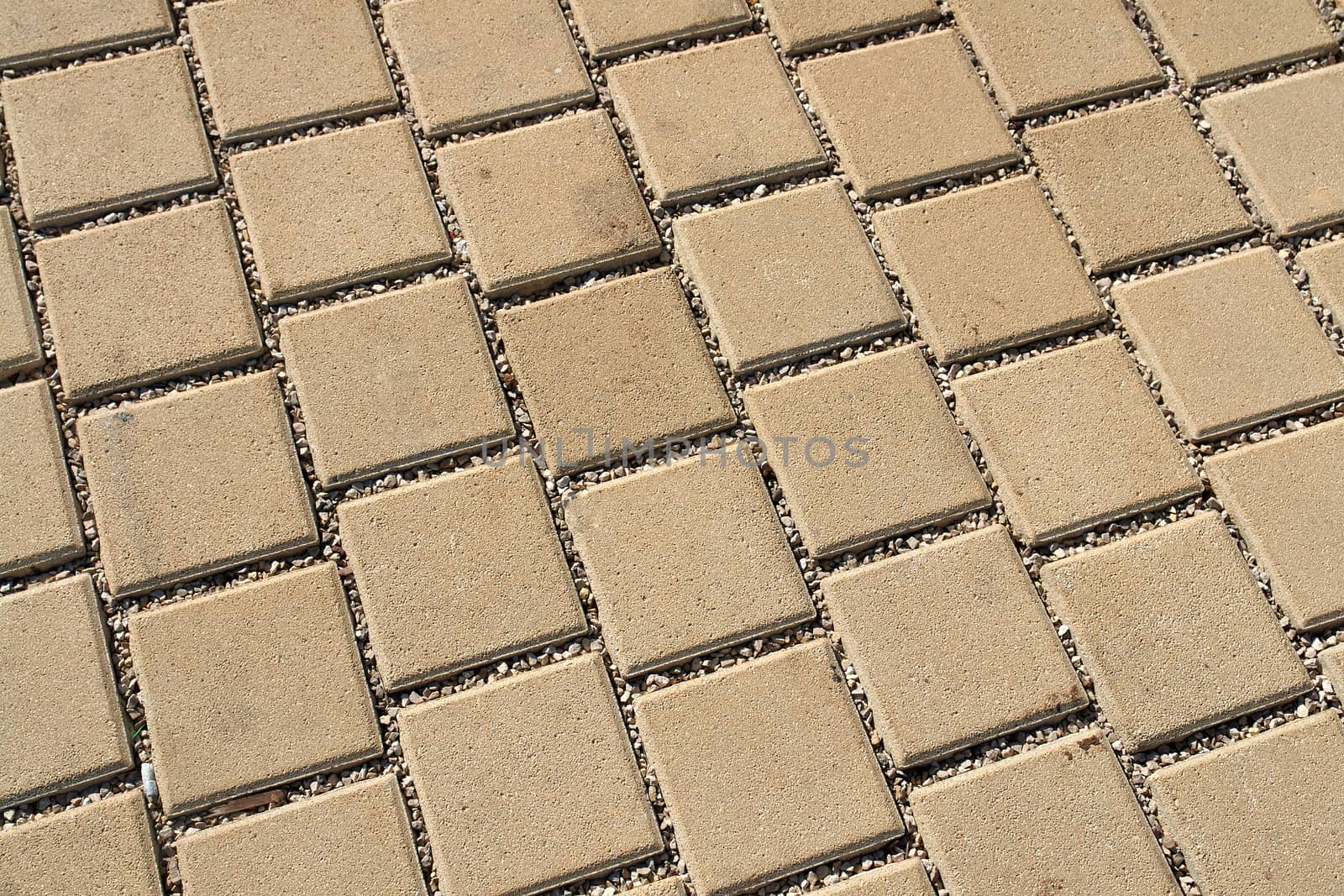 Patterned light brown paving street tiles on the road                               