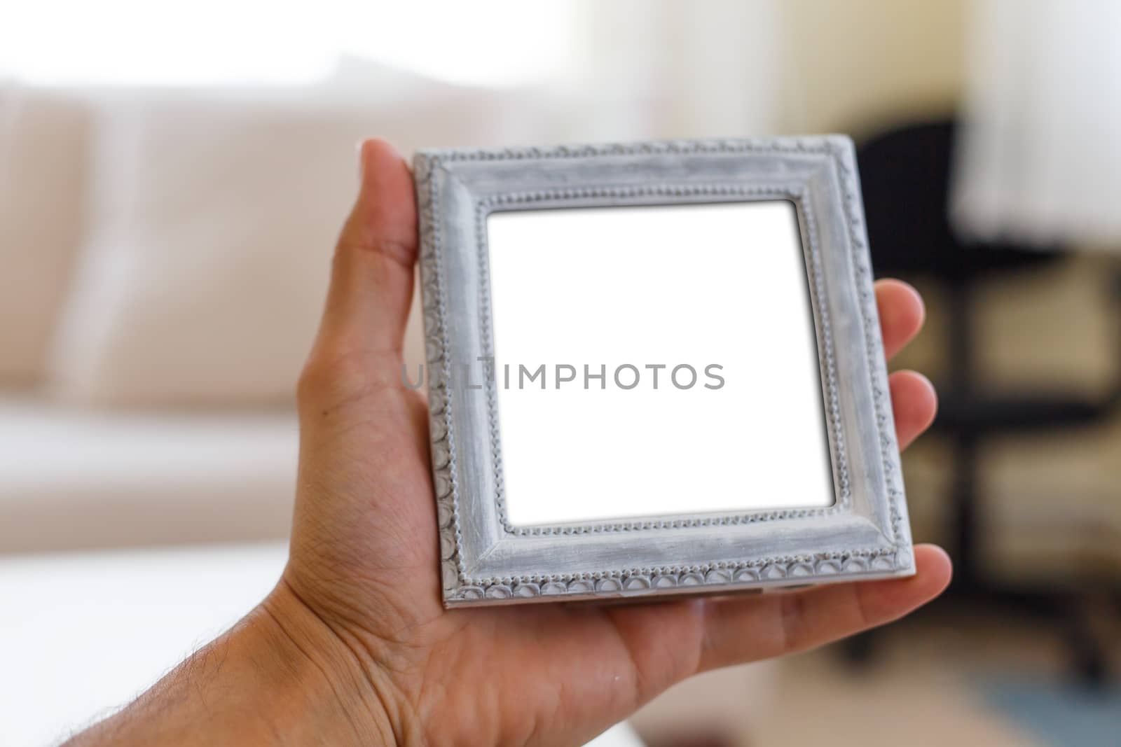Close up detailed front view of white blank wooden frame with copy space, holding on man hand.