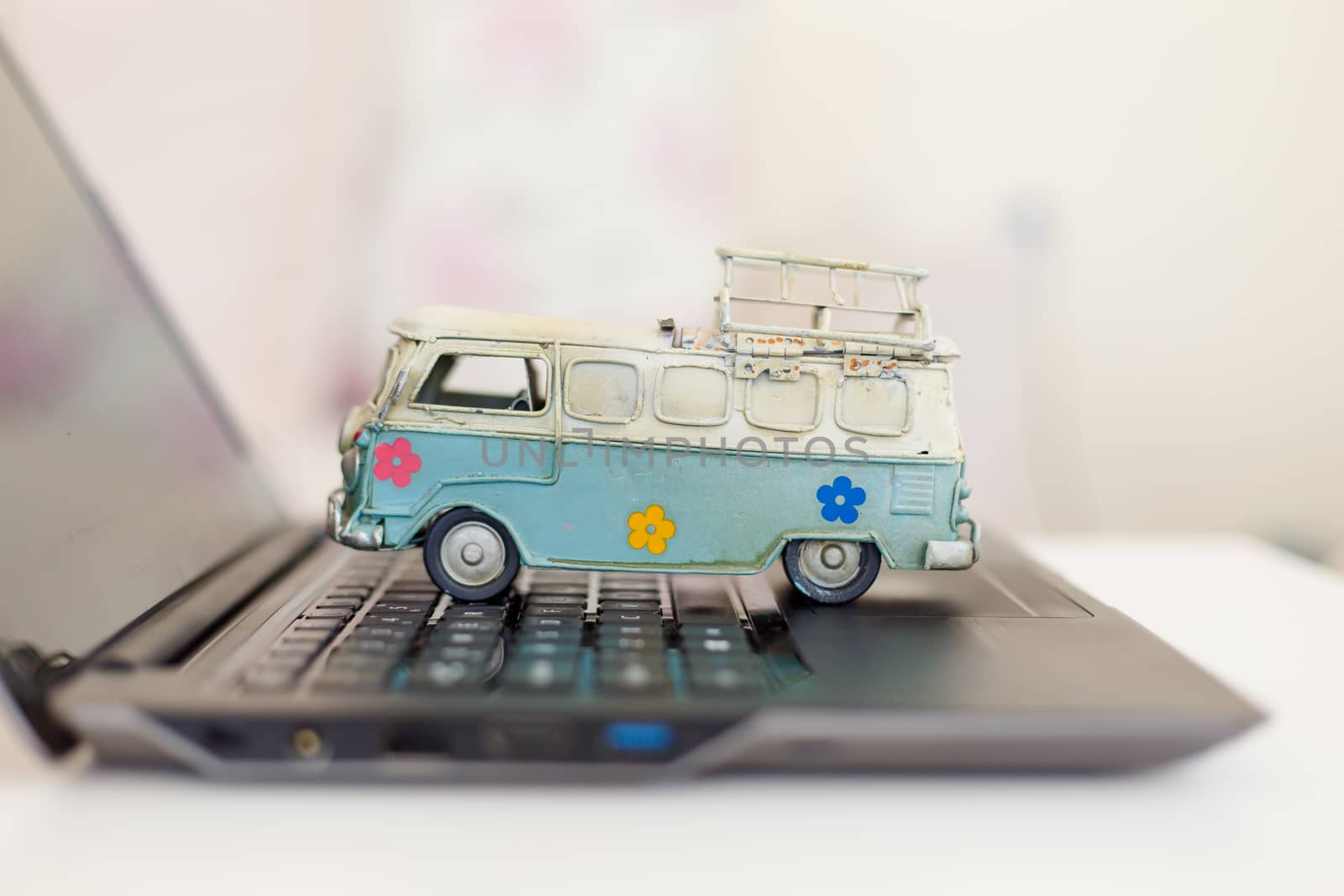 Close up detailed view of a black laptop pc with a colorful toy bus on.