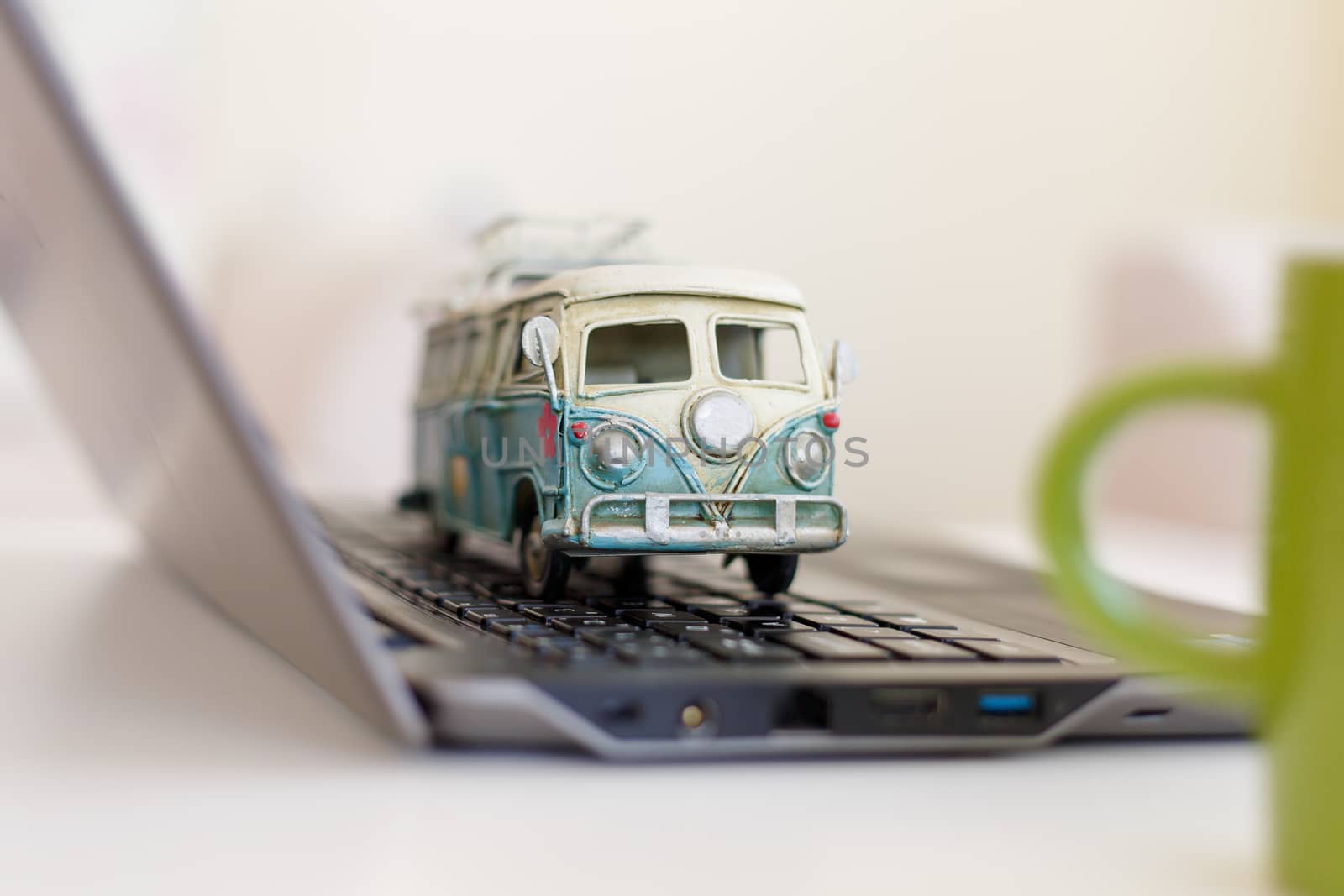 Close up detailed view of a black laptop pc with a colorful toy bus on.