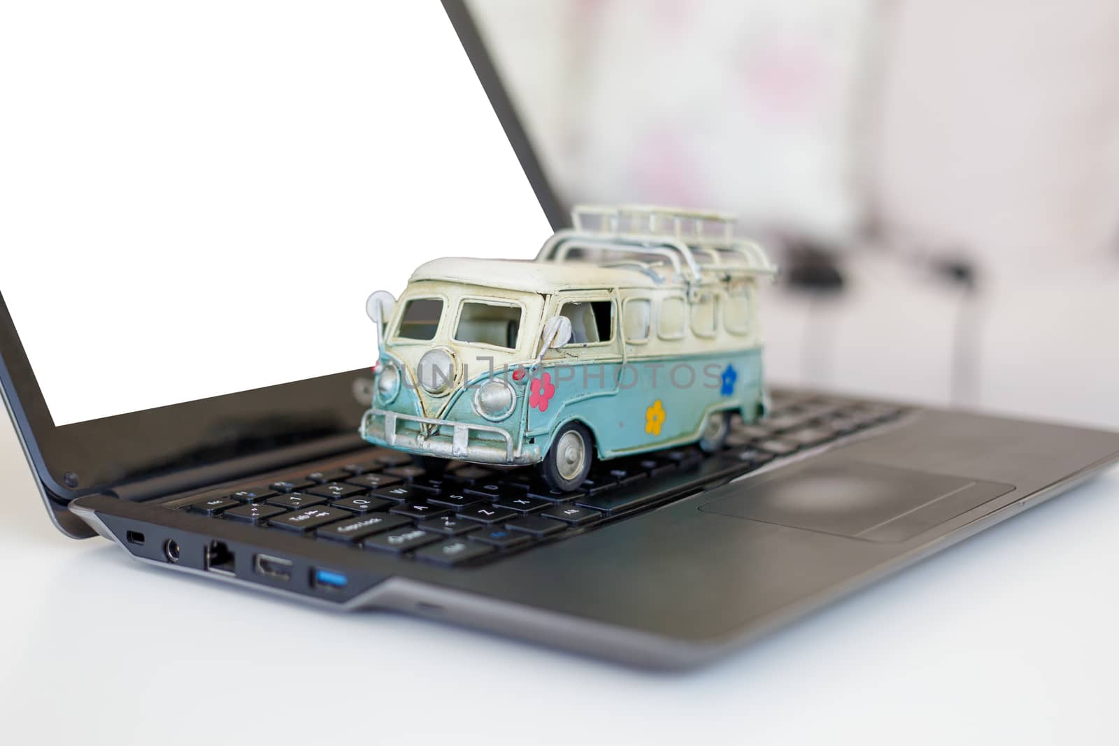 Close up detailed view of a black laptop pc, with blank copy space screen, with a colorful toy bus on.