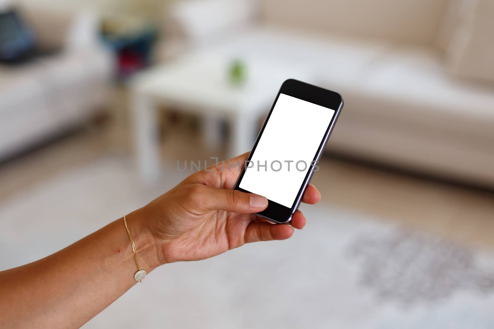 Close up detailed view of a smart phone holding on hand, pushing the button, with white blank copy space screen.