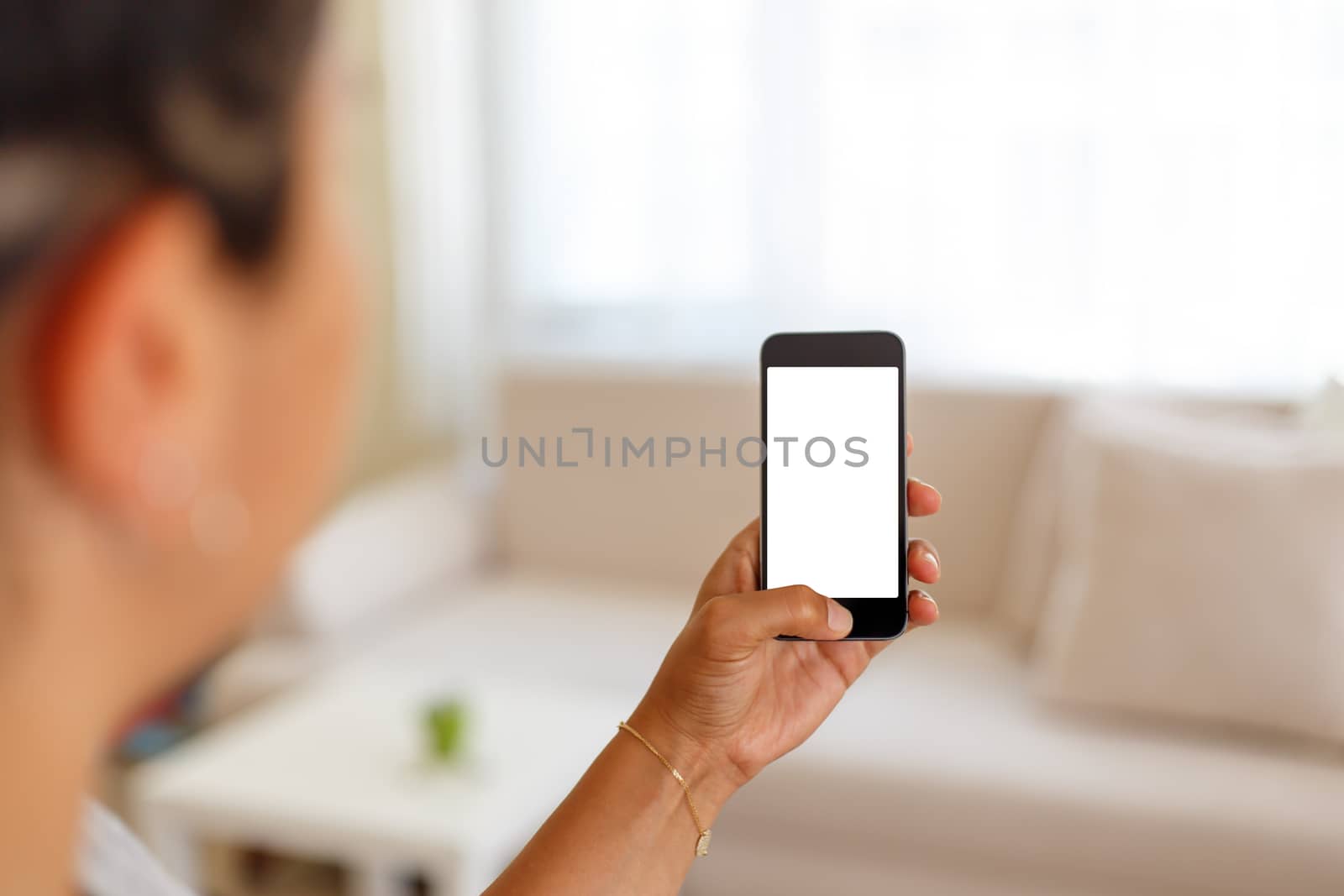 Close up detailed view of a smart phone holding on hand, pushing the button, with white blank copy space screen.