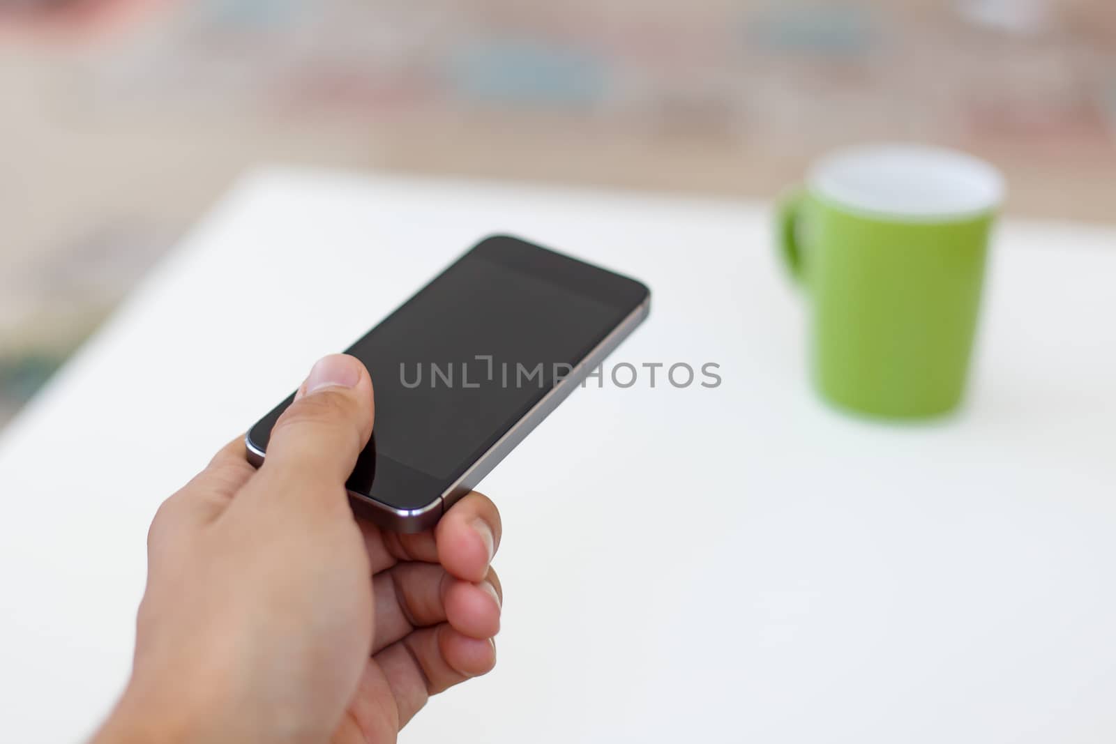Close up detailed view of a black smart phone holding on hand.