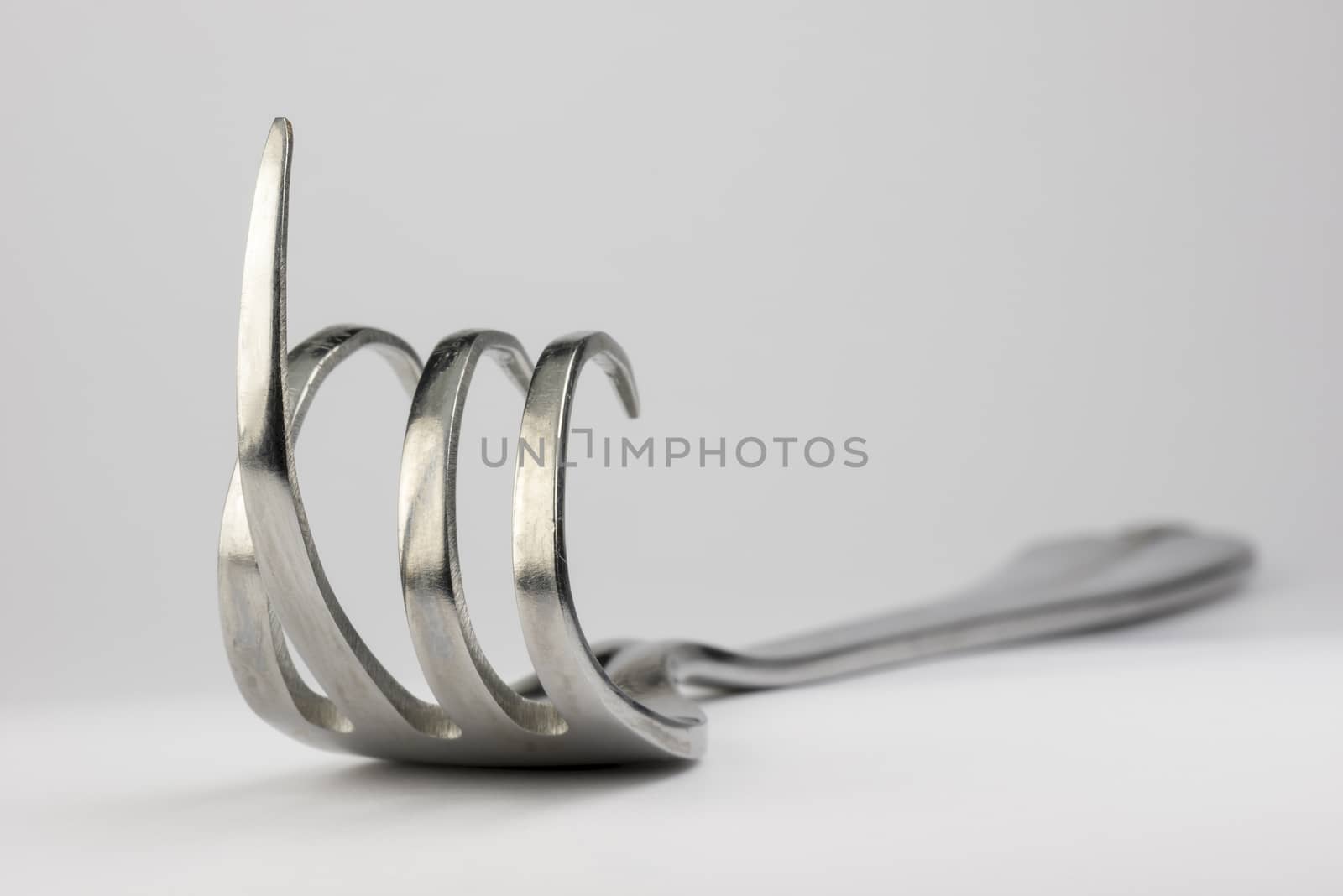 Curved fork with raised middle finger
 by Tofotografie