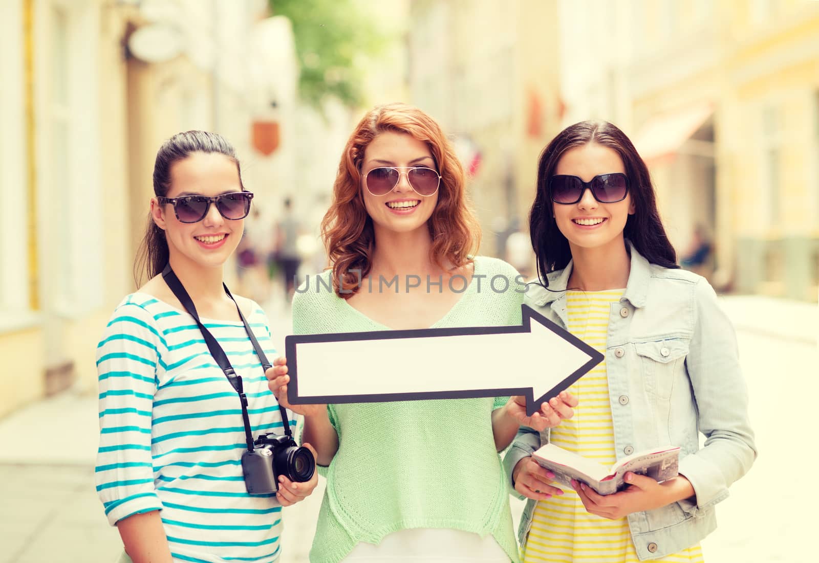 smiling teenage girls with white arrow outdoors by dolgachov