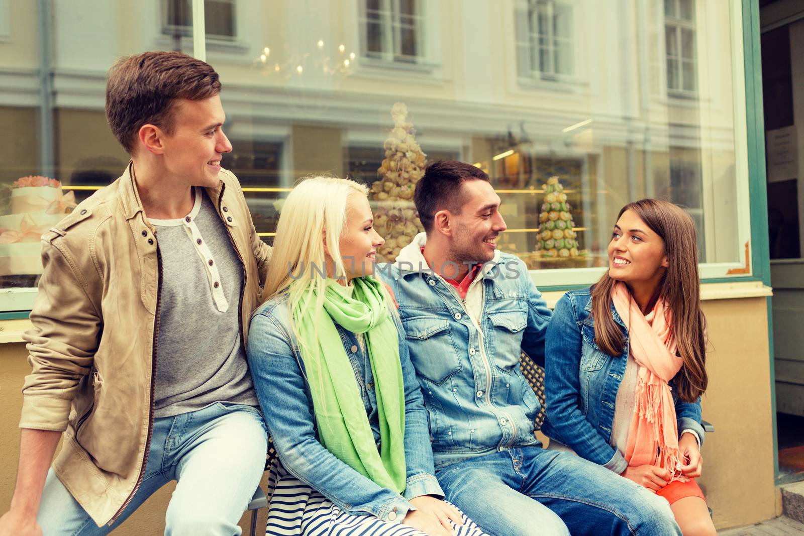 friendship, travel and vacation concept - group of smiling friends in the city