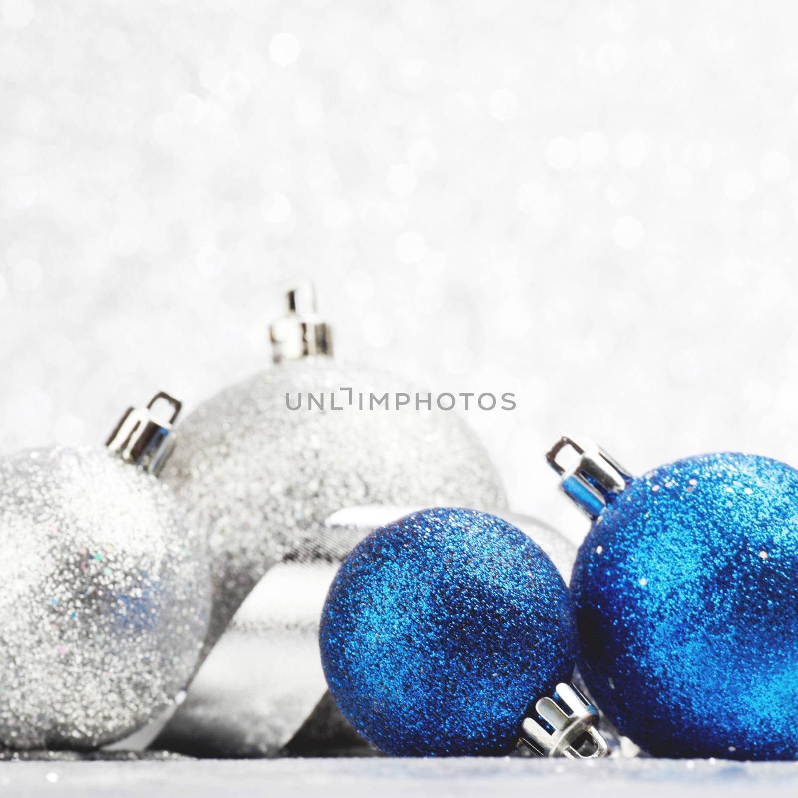 Christmas decorative balls on light silver bokeh background