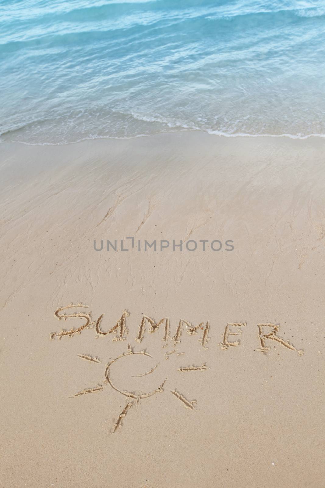 Summer on beach concept - inscription on a beach sand with coming wave