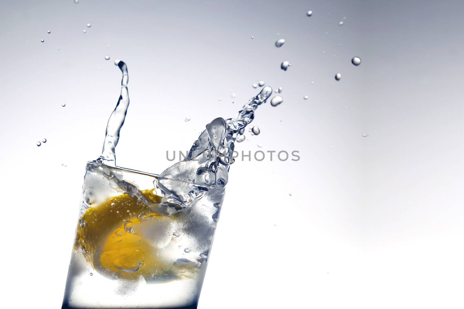 Lemon water and ice cubes isolated on white background