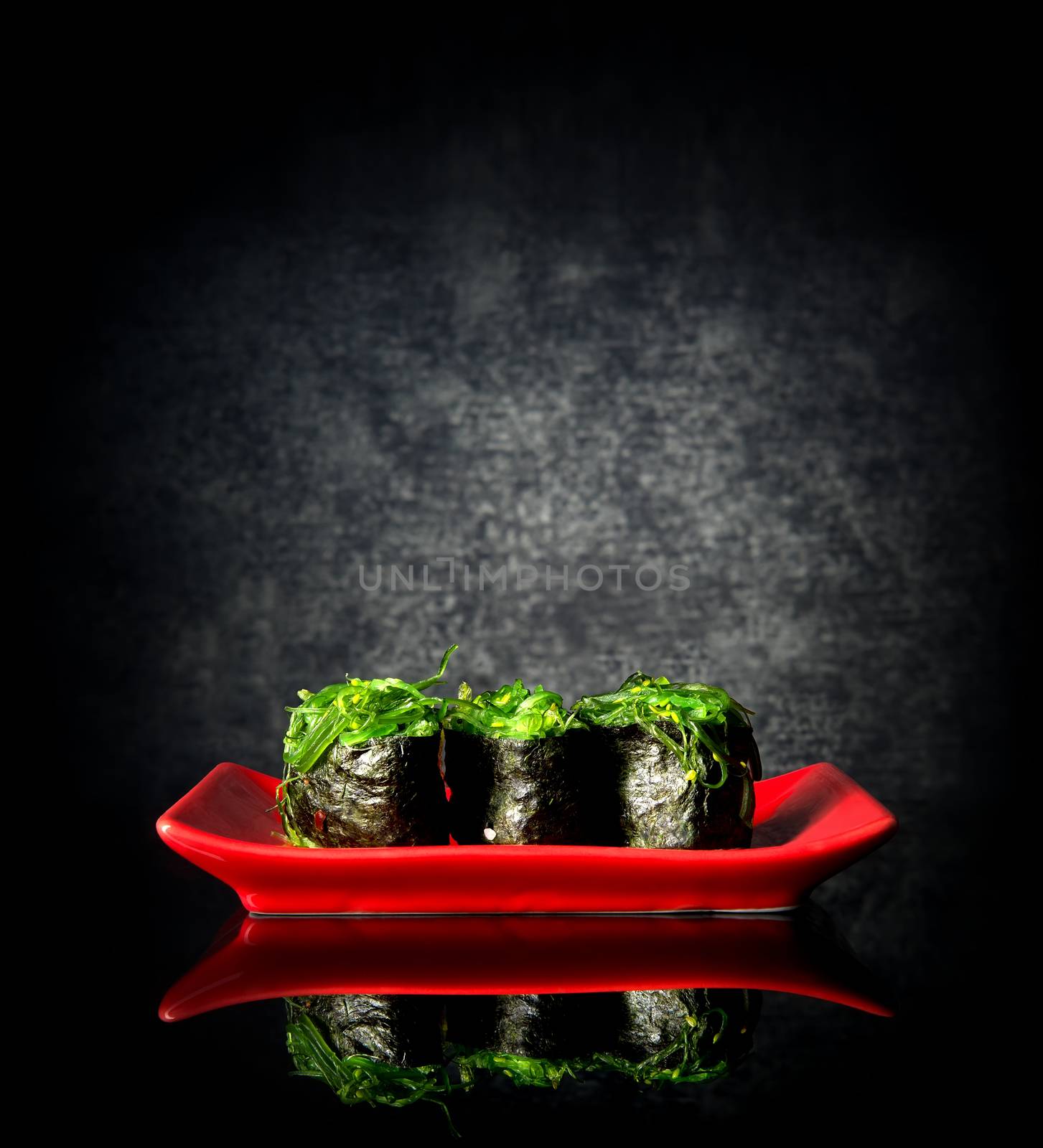 Spicy sushi on red plate and black background