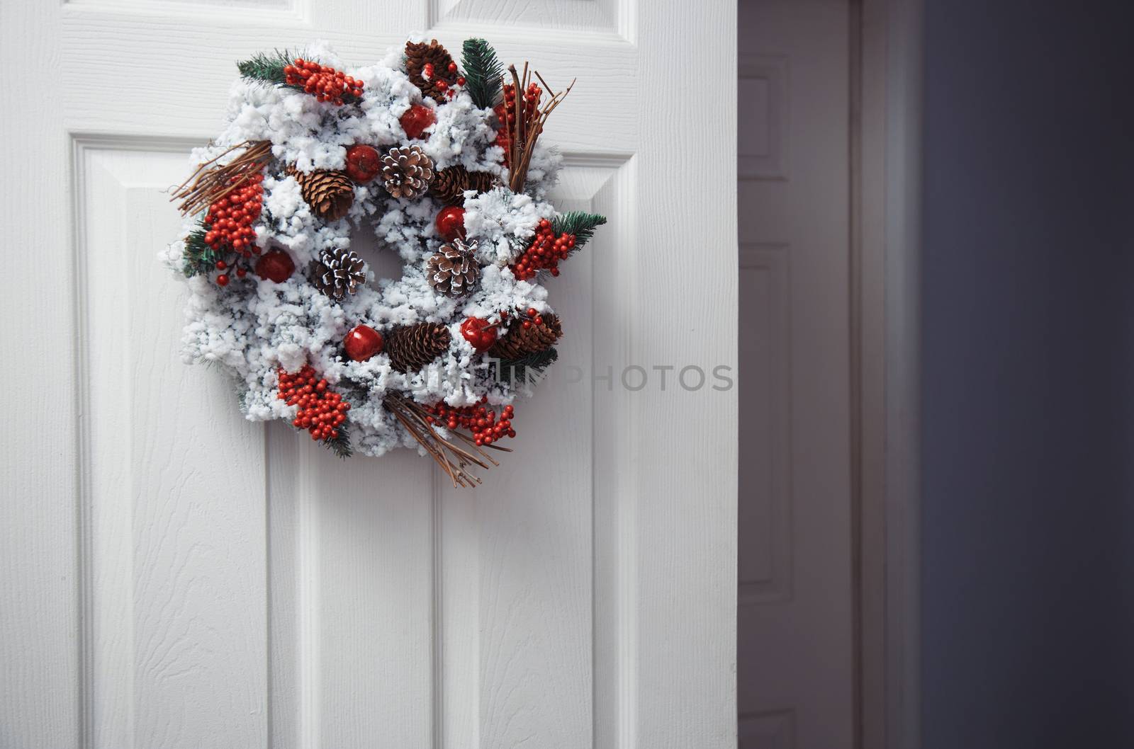 White door with Christmas wreath. Horizontal photo