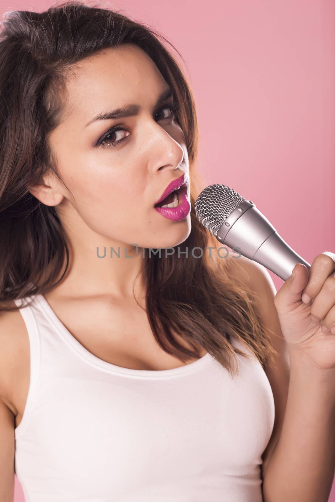 Portrait of a charming and beautiful woman singing with microphone in studio over pink background.







Portrait of a charming and beautiful woman singing with microphone in studio over pink background.