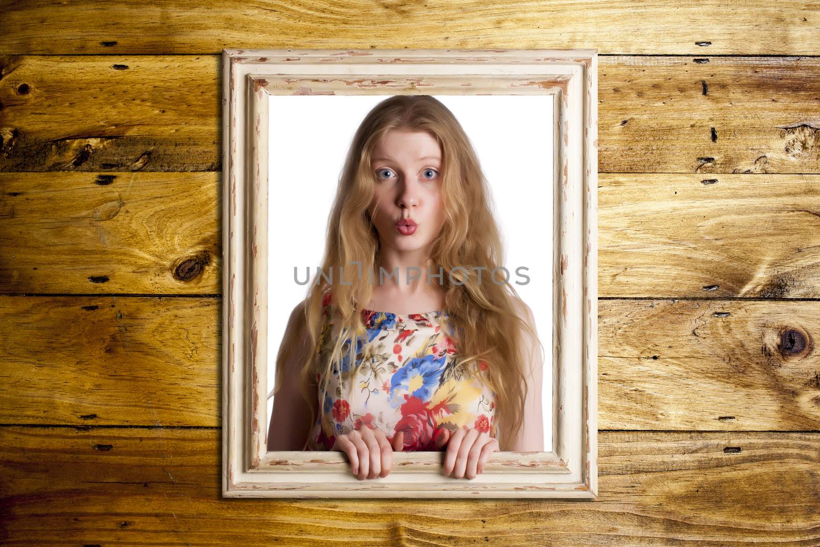 Abstract image of a beautiful woman trapped in a picture frame over a wooden background.