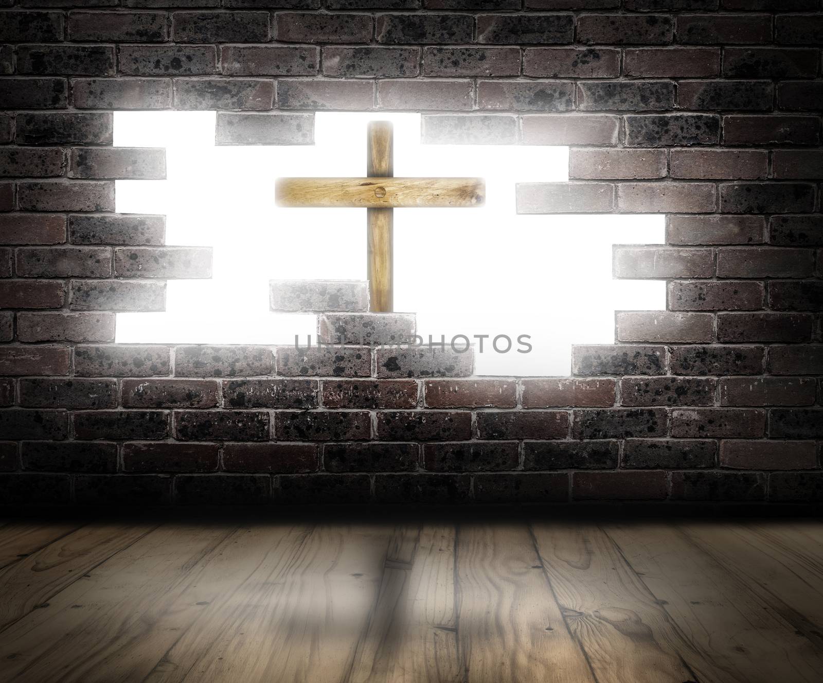 Wooden cross behind a broken brick wall with white light in the background.