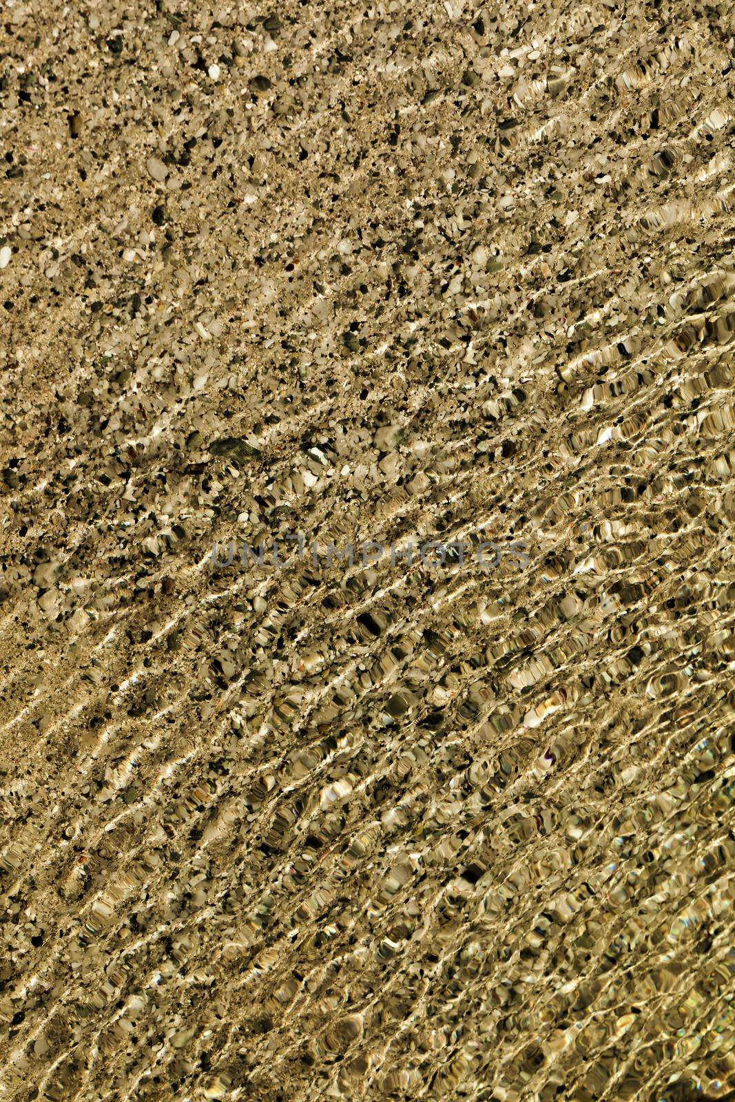 Water flowing over different coloured rocks as a abstract water background.