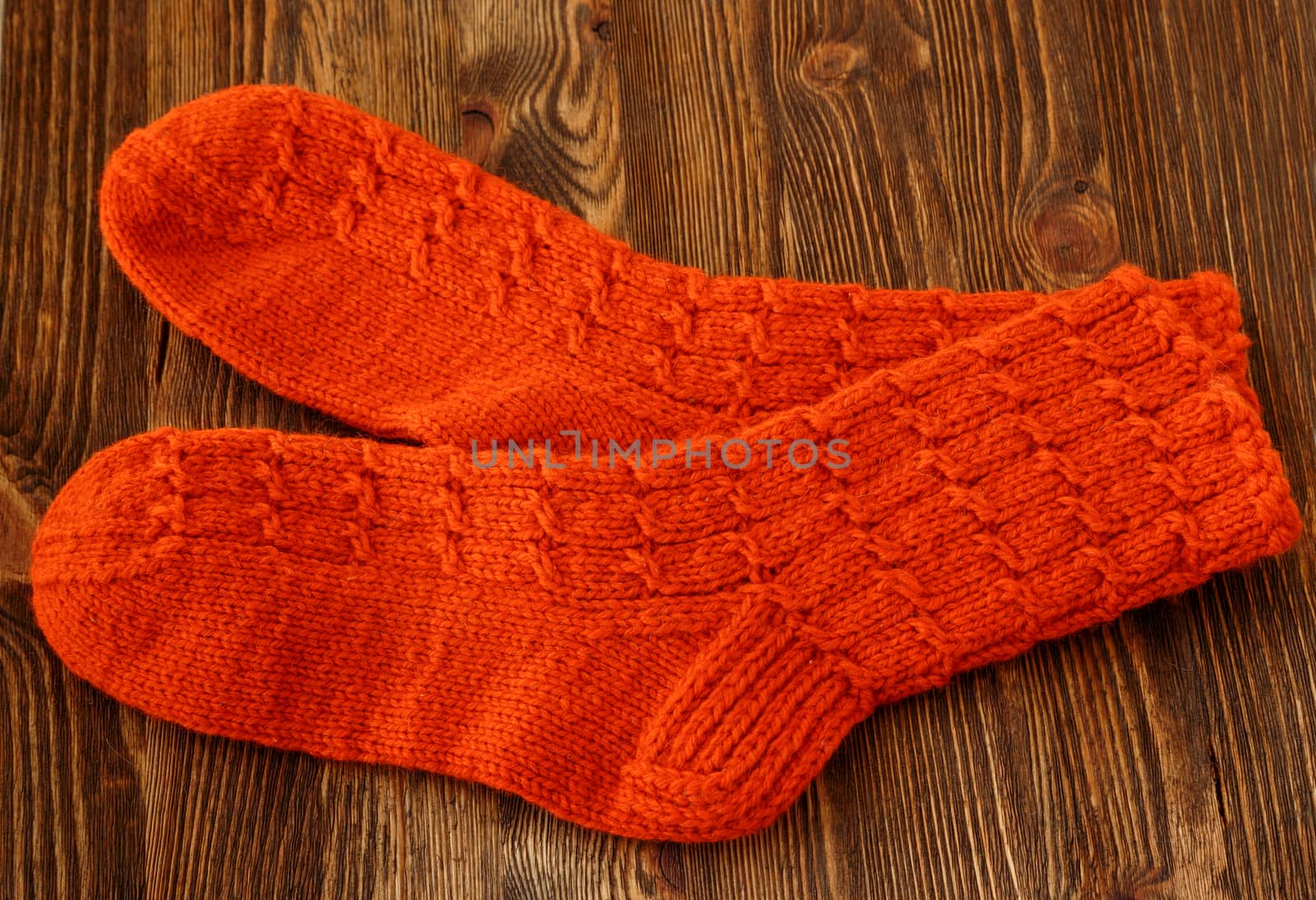 wool orange socks on a brown wooden background