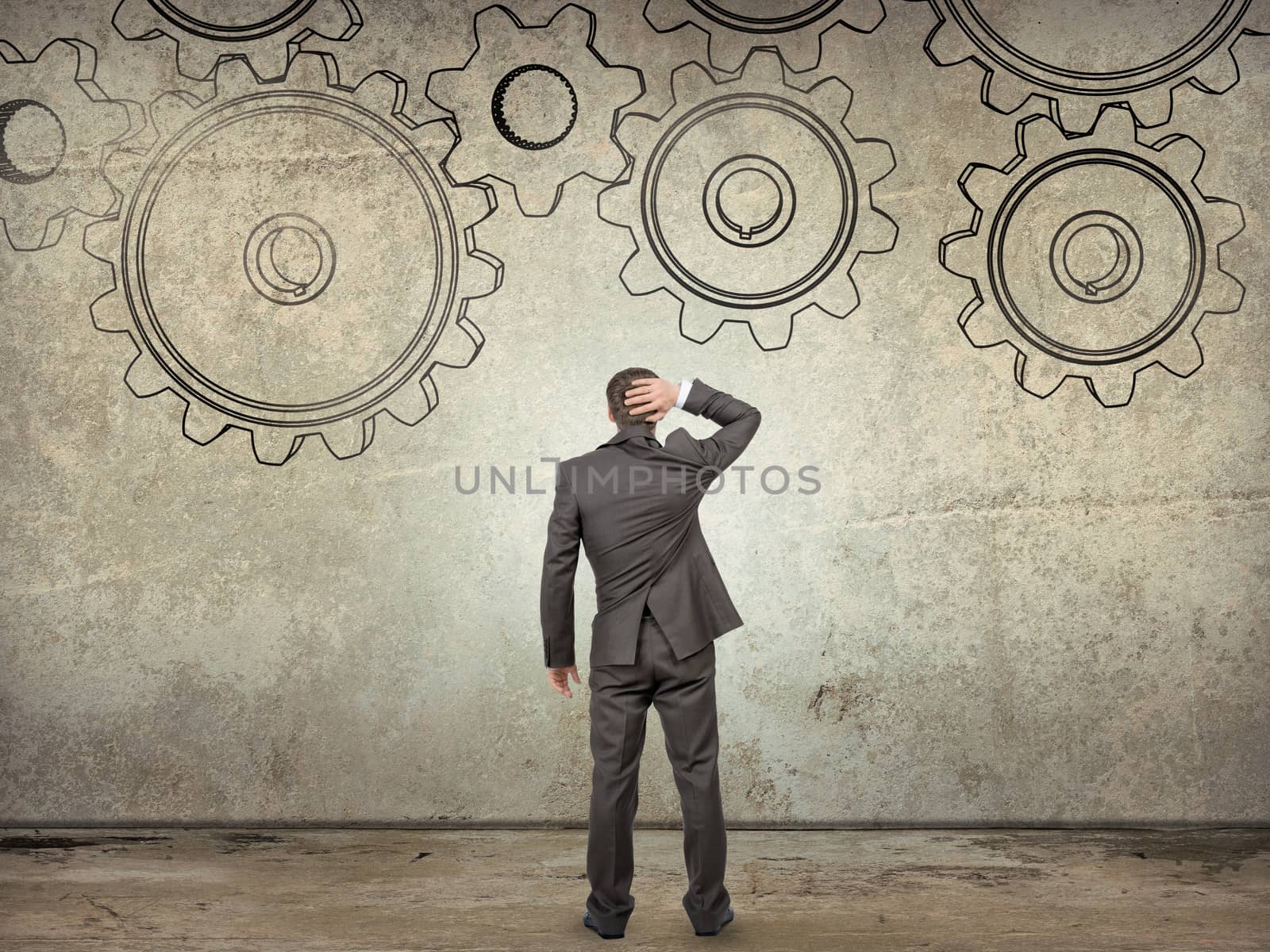 Businessman looking at cog wheels on abstract background