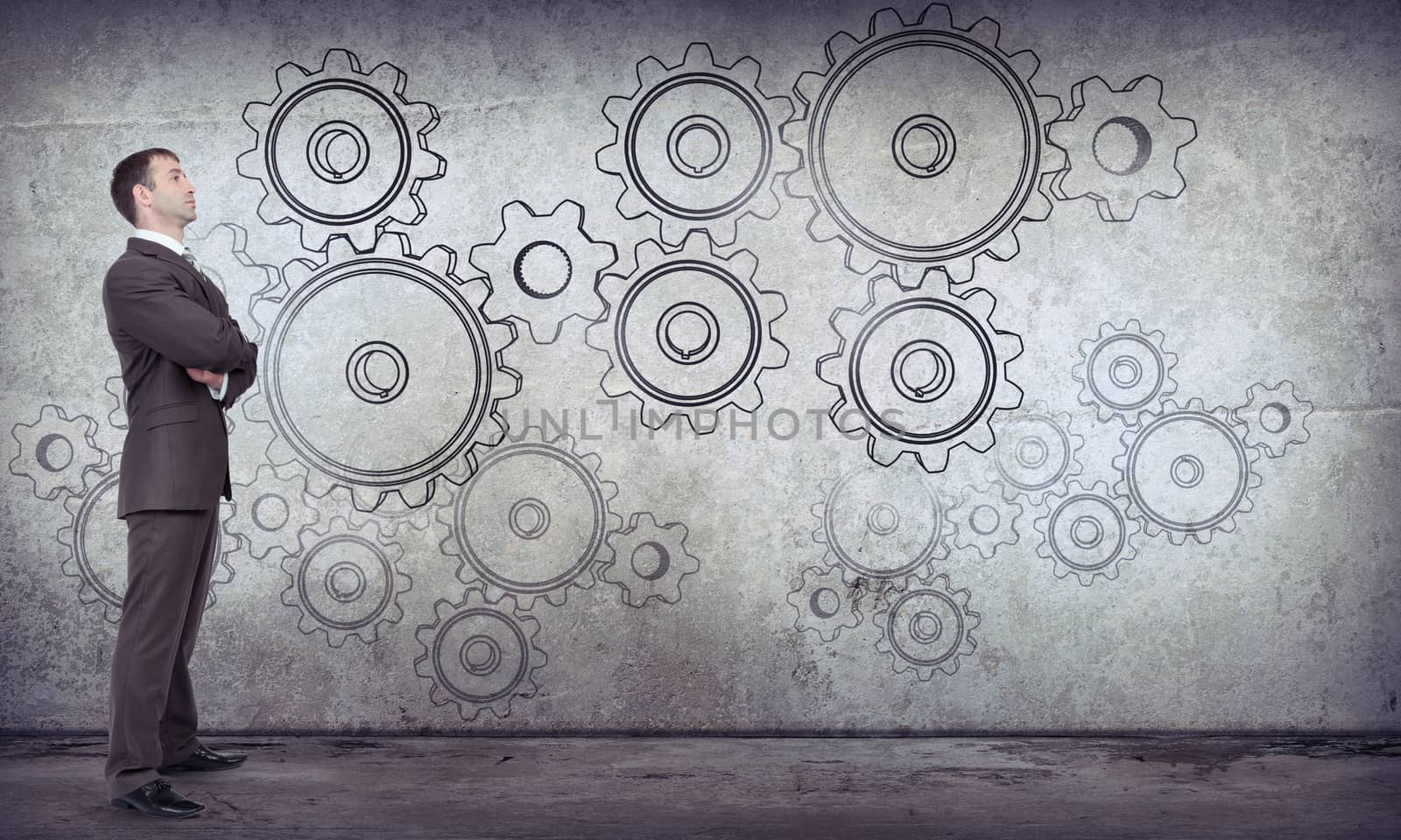 Businessman with cog wheels on abstract background