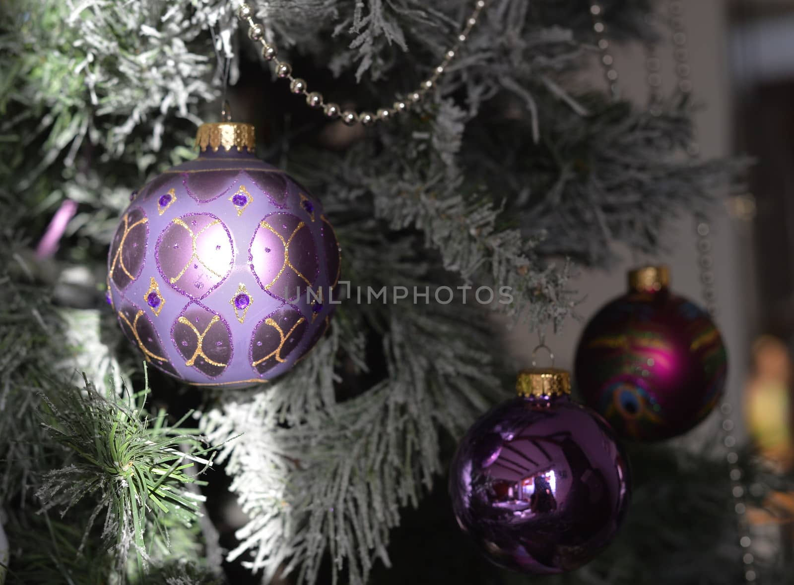 Background with a snowy pine tree and Christmas purple ornamated ball. by kertis