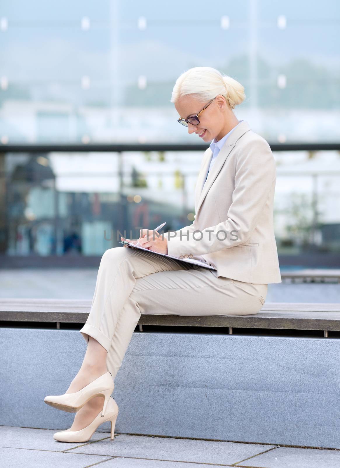 young smiling businesswoman with notepad outdoors by dolgachov