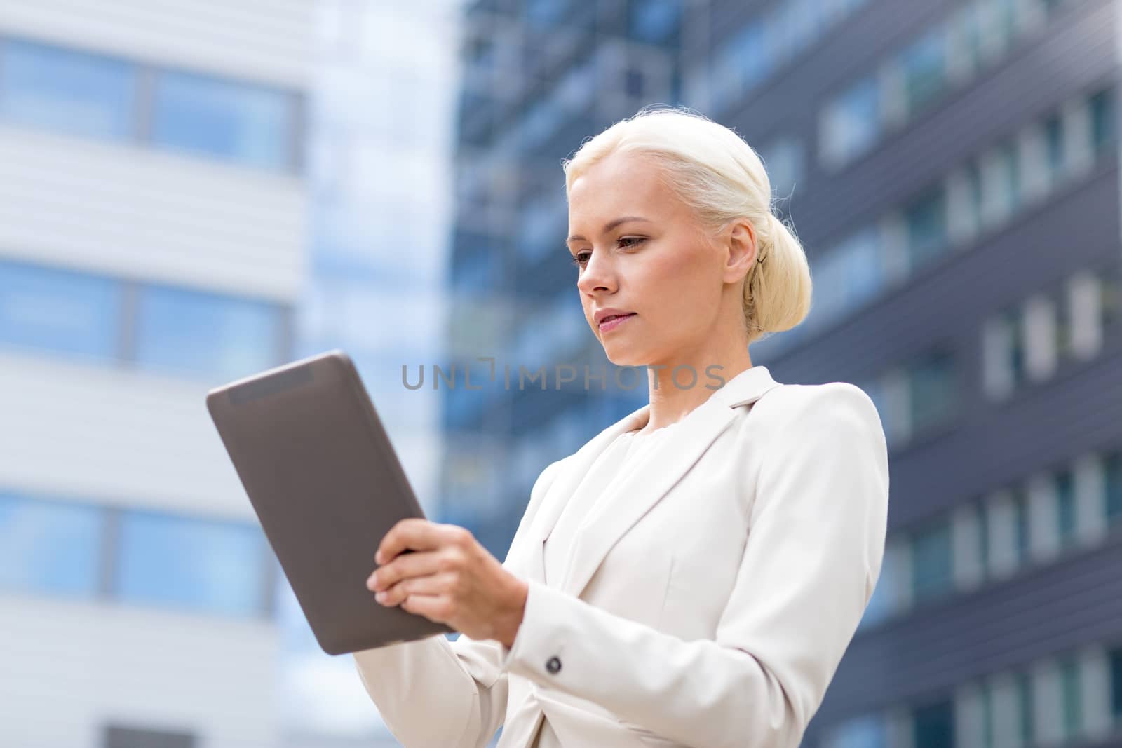 business, education, technology and people concept - businesswoman working with tablet pc computer on city street