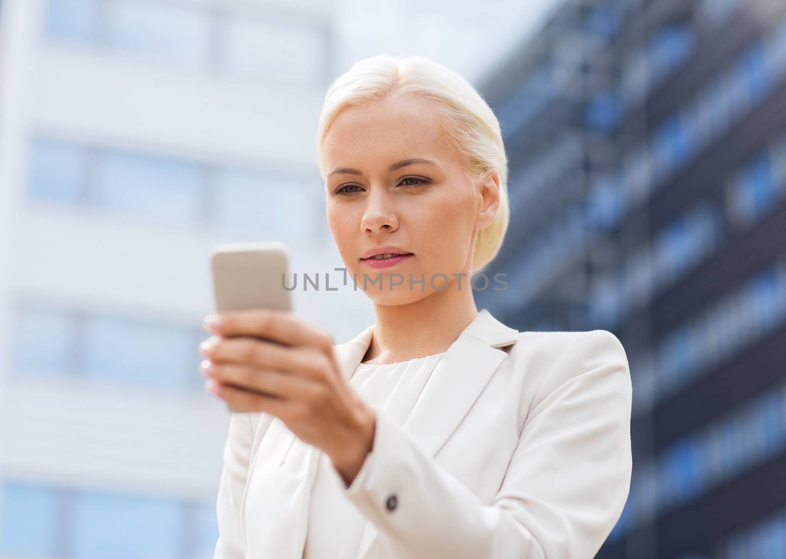 serious businesswoman with smartphone outdoors by dolgachov