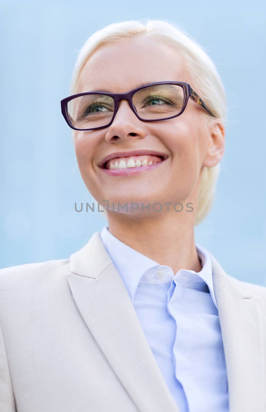 young smiling businesswoman over office building by dolgachov