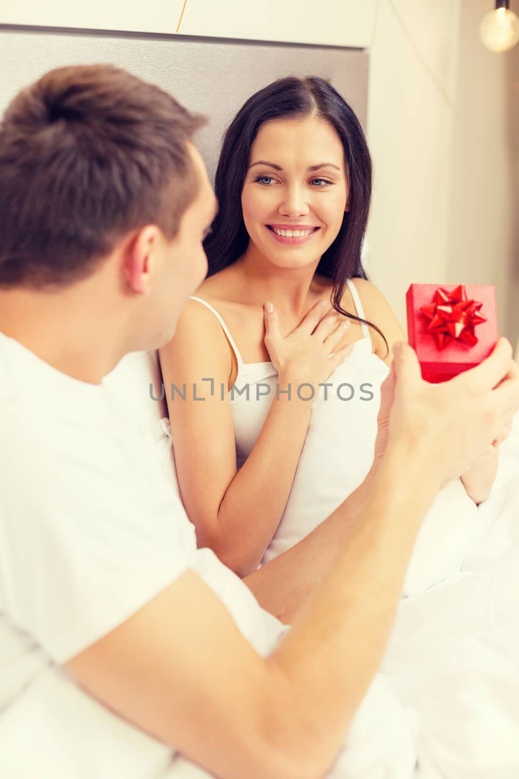 man giving woman little red gift box by dolgachov