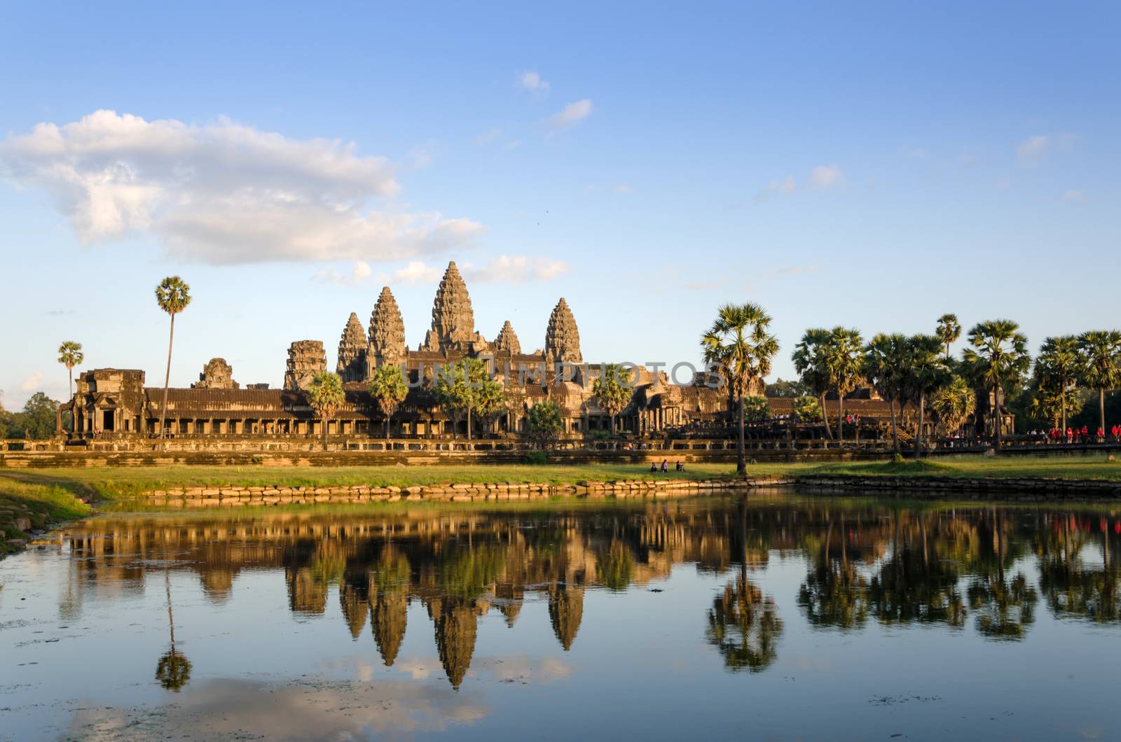 Angkor Wat at sunset with reflection in water by siraanamwong