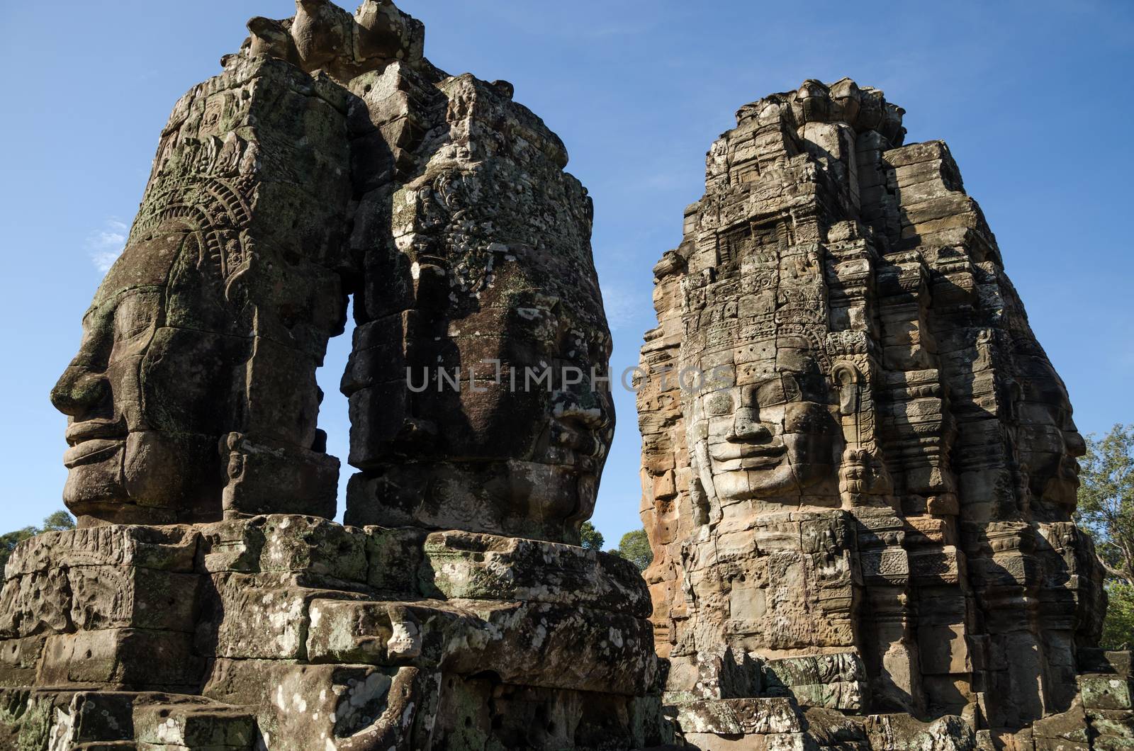 Giant stone faces of Bayon temple in Angkor Thom by siraanamwong