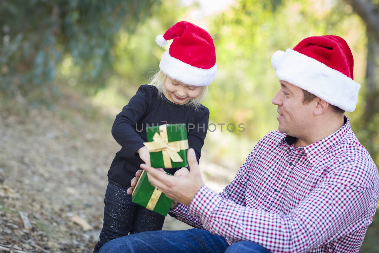 Happy Father Giving Young Daughter A Christmas Gift Outdoors.